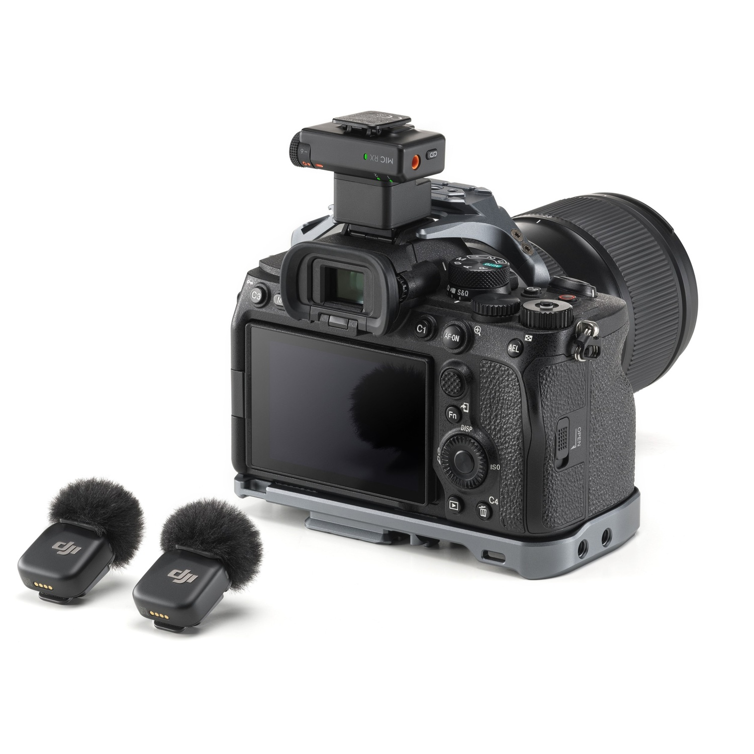 Een zwarte camera met bevestigde microfoon en twee draadloze microfoons. De camera staat op een grijs metalen frame, op een witte achtergrond.