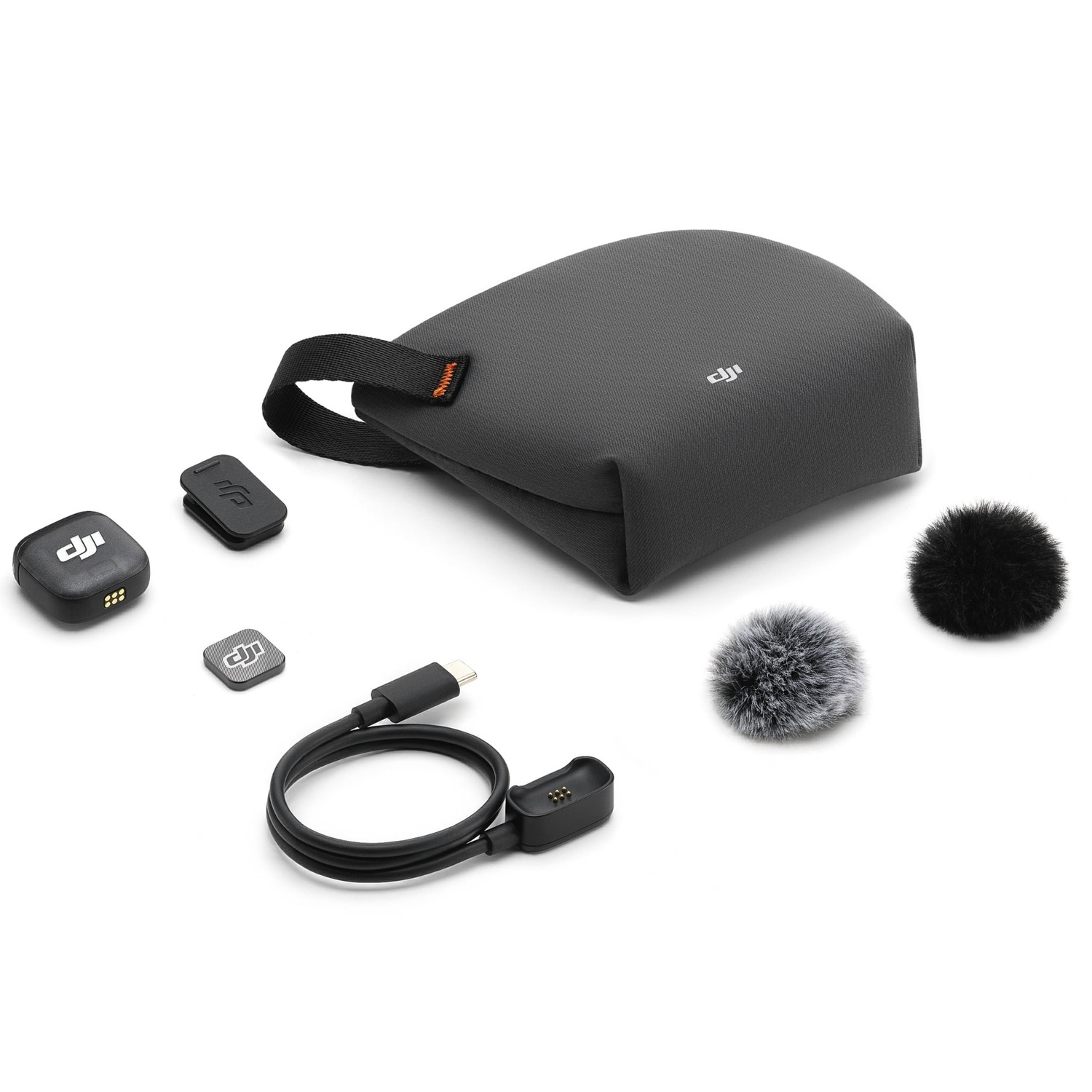 DJI microfoonkit op wit. Bevat een tas, twee microfoons, een USB-kabel, een oplaadadapter en twee pluizige windschermen.