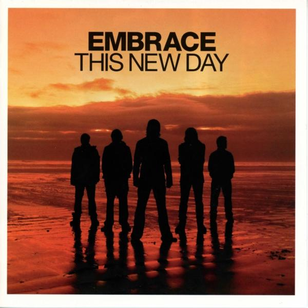 Sziluettek állnak a strandon, narancssárga naplementét tükrözve. A tetején az „EMBRACE THIS NEW DAY” felirat látható.