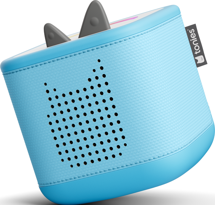 Eine blaue Toniebox mit grauen Ohren, einem Lautsprecherdesign und einem Markenetikett. Sie hat einen abgerundeten Boden und eine strukturierte Oberfläche.