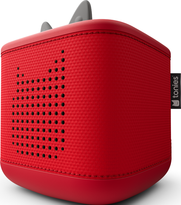Ein roter, würfelförmiger Toniebox mit strukturierter Oberfläche und Lautsprechergitter. Oben hat er graue Ohren und einen 'tonies'-Anhänger an der Seite.