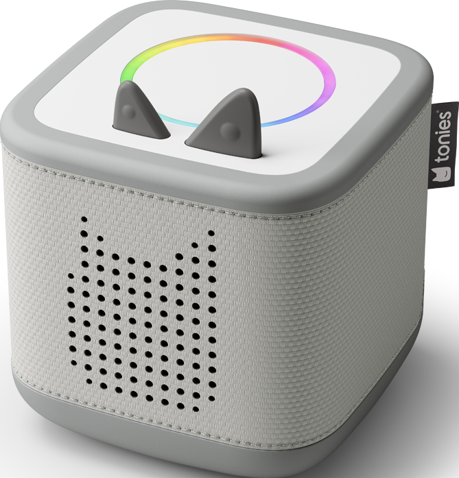Un haut-parleur gris en forme de cube avec des oreilles de chat et une lumière arc-en-ciel. Il a une grille de haut-parleur et une étiquette 'tonies'.
