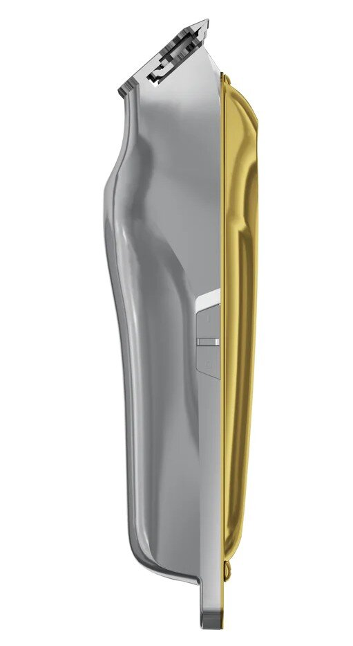 Srebrna i złota maszynka do włosów jest pokazana na białym tle. Maszynka jest ustawiona pod kątem, pokazując swój kształt.