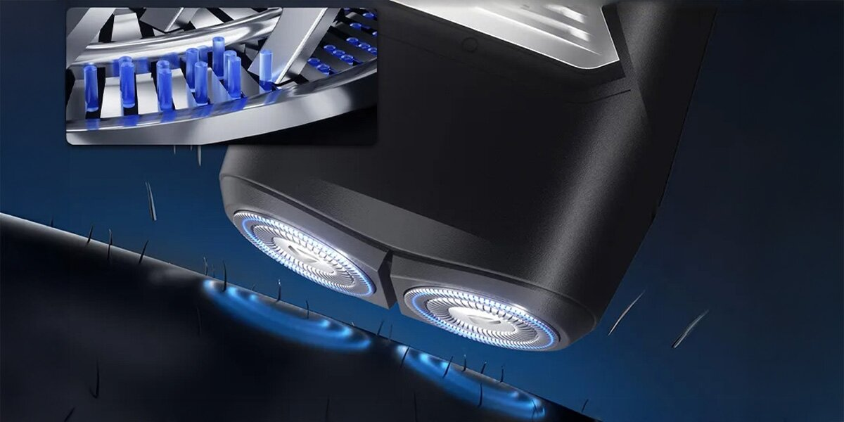 Szczegółowo pokazano golarkę elektryczną. Widoczne są dwie obracające się głowice z niebieskimi podświetleniami. Włosy są ścinane. Wstawka z bliska pokazuje elementy.