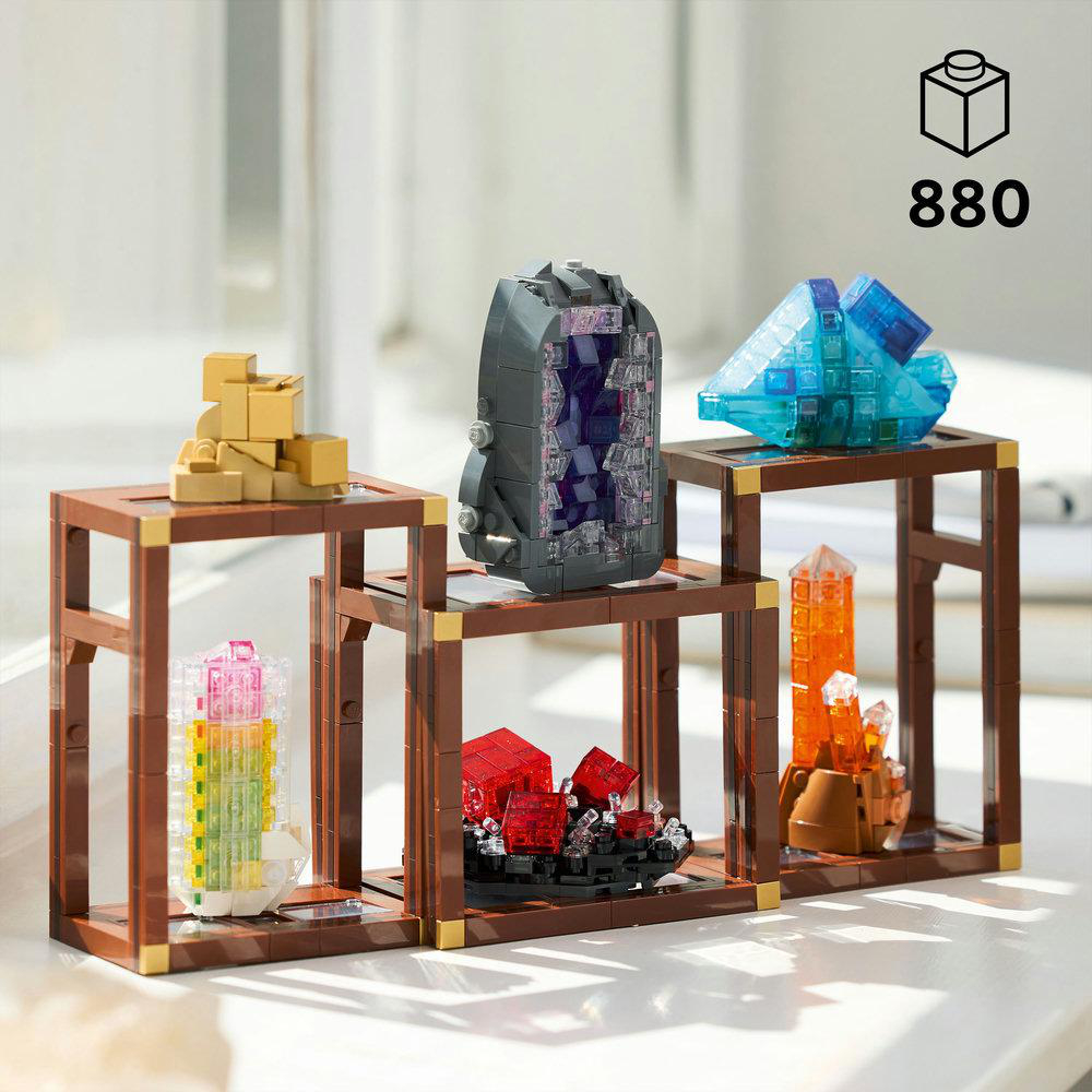 Drei Holzständer mit Lego-Kristallen. Oben befinden sich goldene, graue und blaue Kristalle. Unten sind rote, orangefarbene und rosa Kristalle.