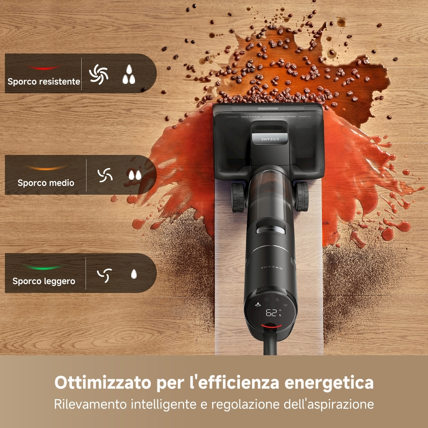 Un aspirapolvere nero sta pulendo una superficie di legno con caffè versato e chicchi di caffè. Il pulitore mostra 62%.