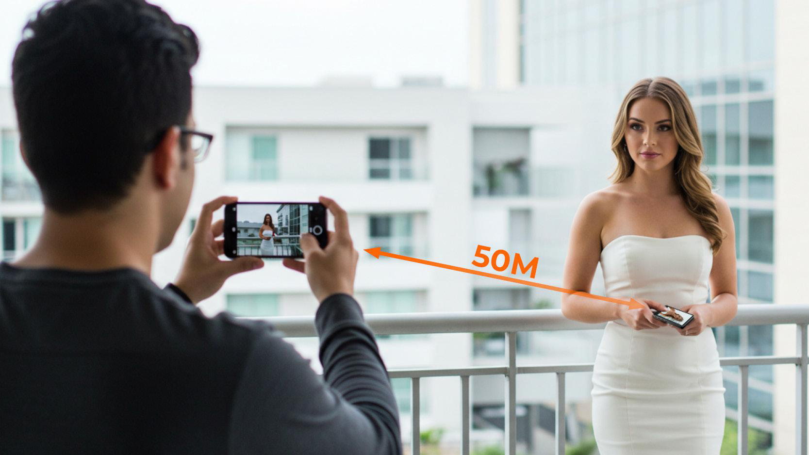 Eine Person fotografiert eine Frau in einem weißen Kleid auf einem Balkon. Ein Pfeil für 50 m Entfernung ist eingezeichnet.
