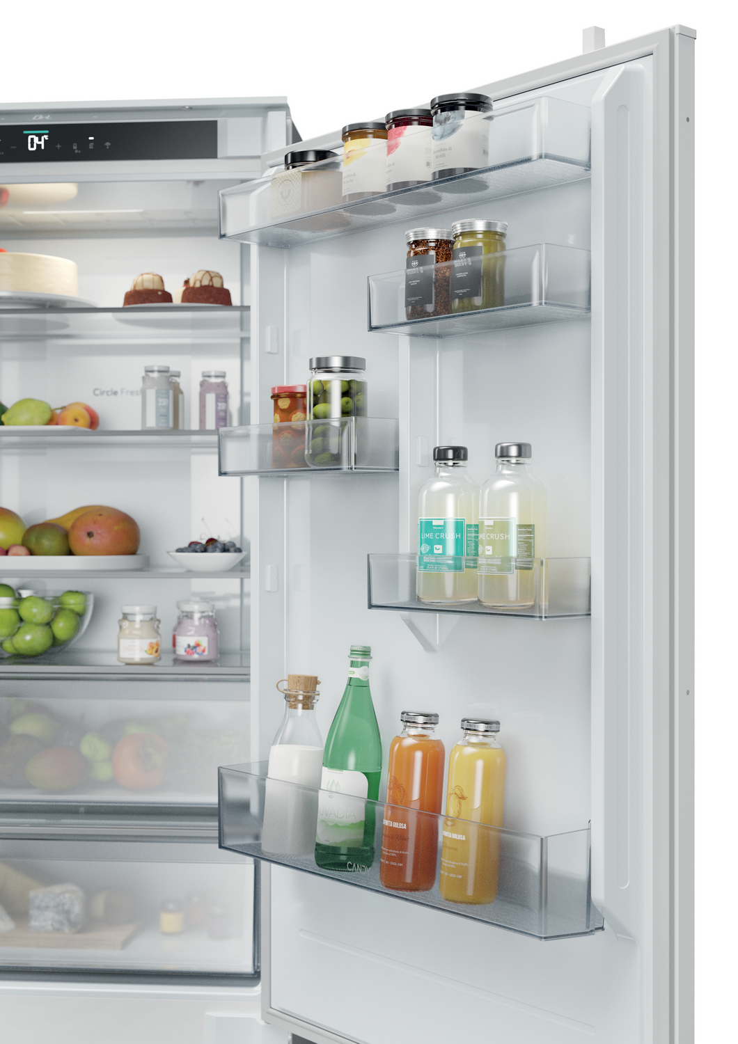 Refrigerador abierto lleno de frascos, botellas, frutas y postres. Los artículos en los estantes incluyen mermeladas, jugo, leche y un pastel.