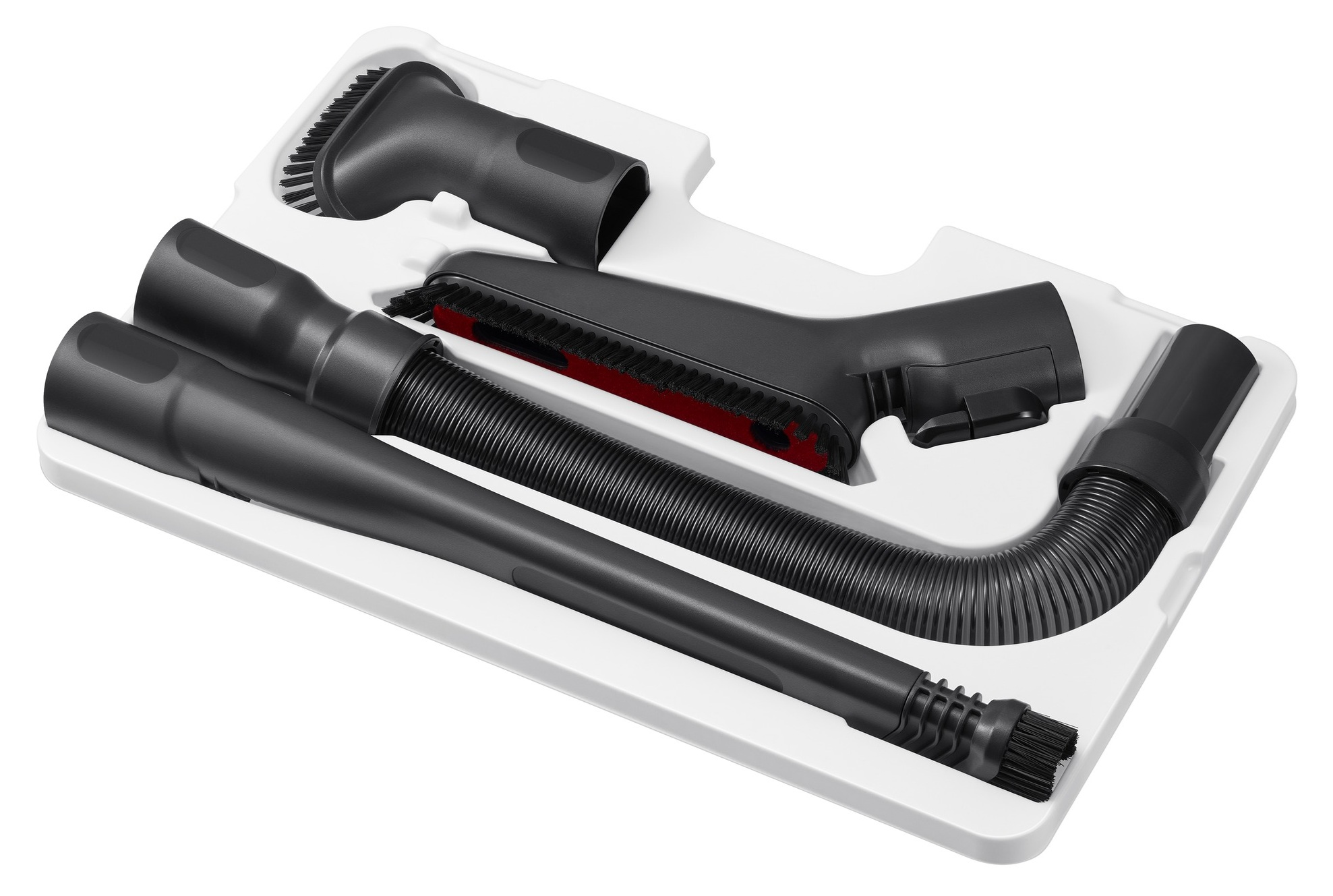 Czarne akcesoria do odkurzacza w białej tacy. Zawiera szczotkę, ssawkę szczelinową i elastyczny wąż.