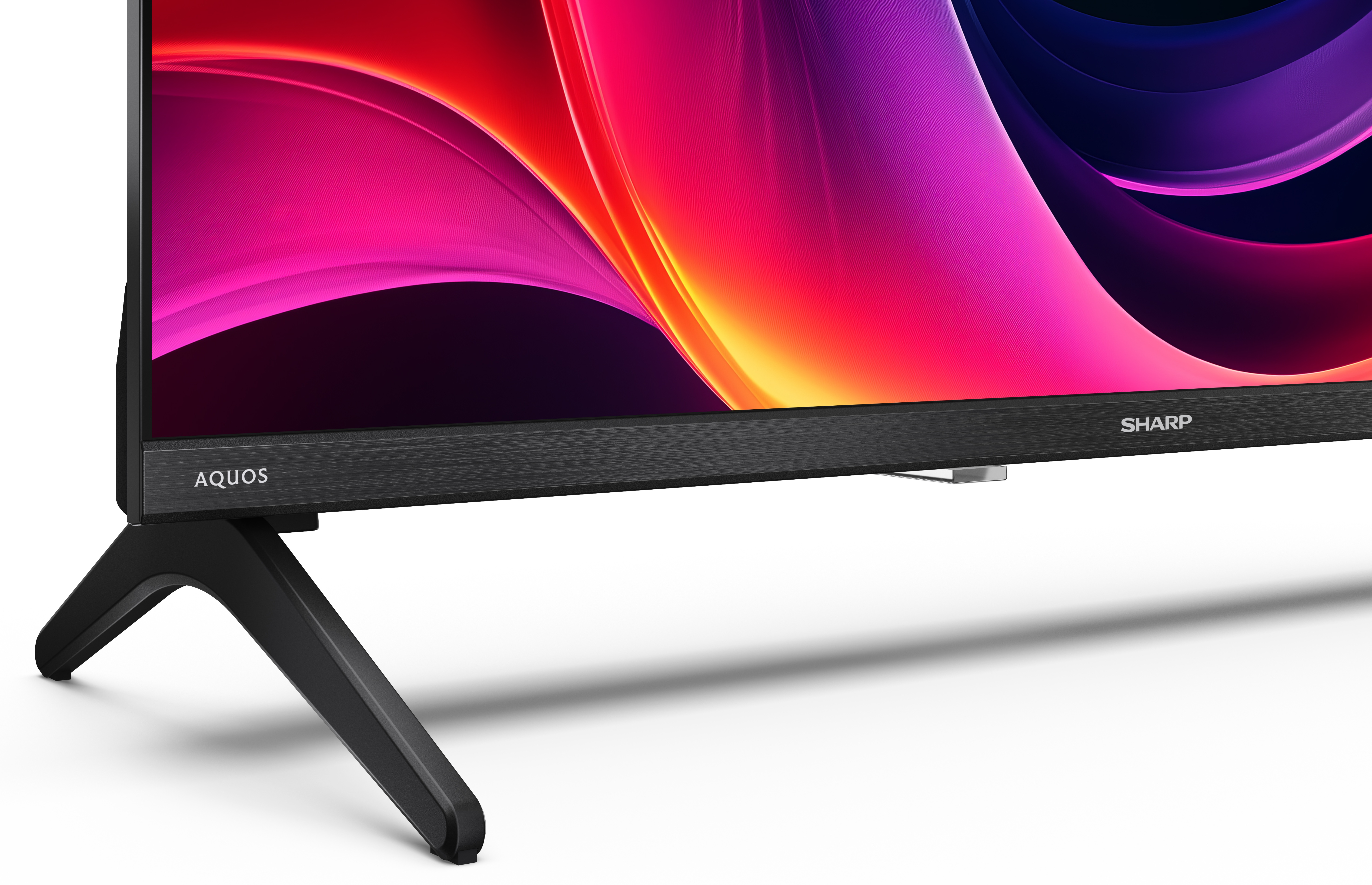 Czarny telewizor Sharp z kolorowym ekranem w kolorach różowym, czerwonym i fioletowym. Telewizor ma czarną podstawę.