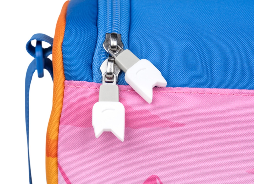 Nahaufnahme einer bunten Lunchtasche mit zwei weißen, zahnförmigen Reißverschlussanhängern. Die Tasche ist blau, rosa, orange und hat einen blauen Riemen.