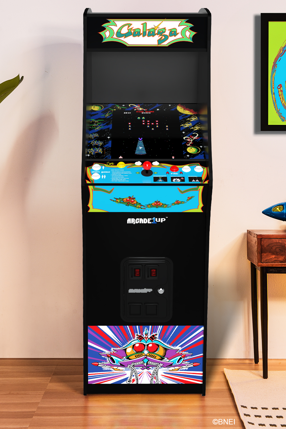 Egy Arcade1Up Galaga arcade gép. Fekete, van rajta egy képernyő, ami a játékot mutatja, és a játék logója felül.