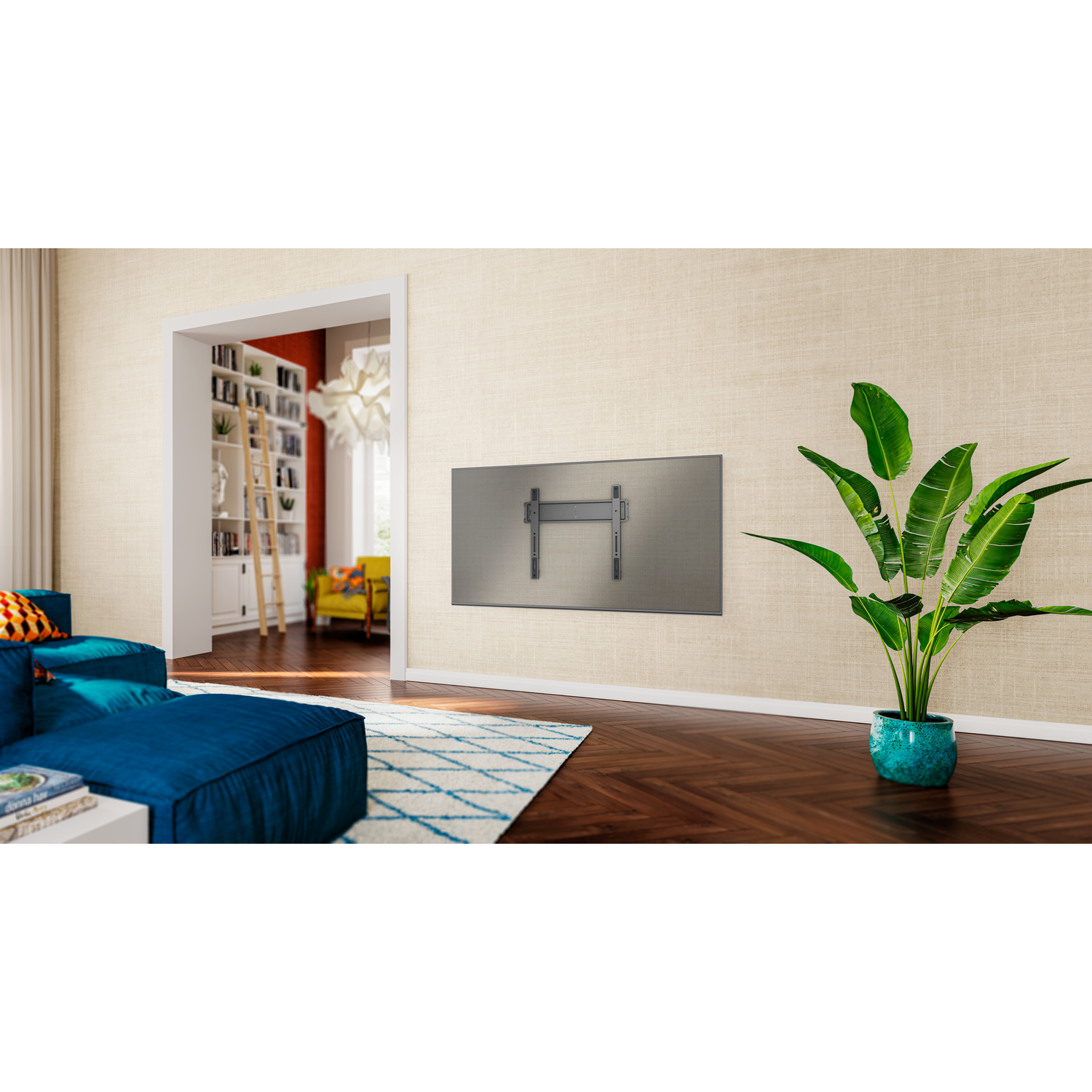 Een woonkamer met een tv-beugel aan de muur. Een blauwe bank, een patroonkleed en een plant in een turquoise pot zijn zichtbaar.