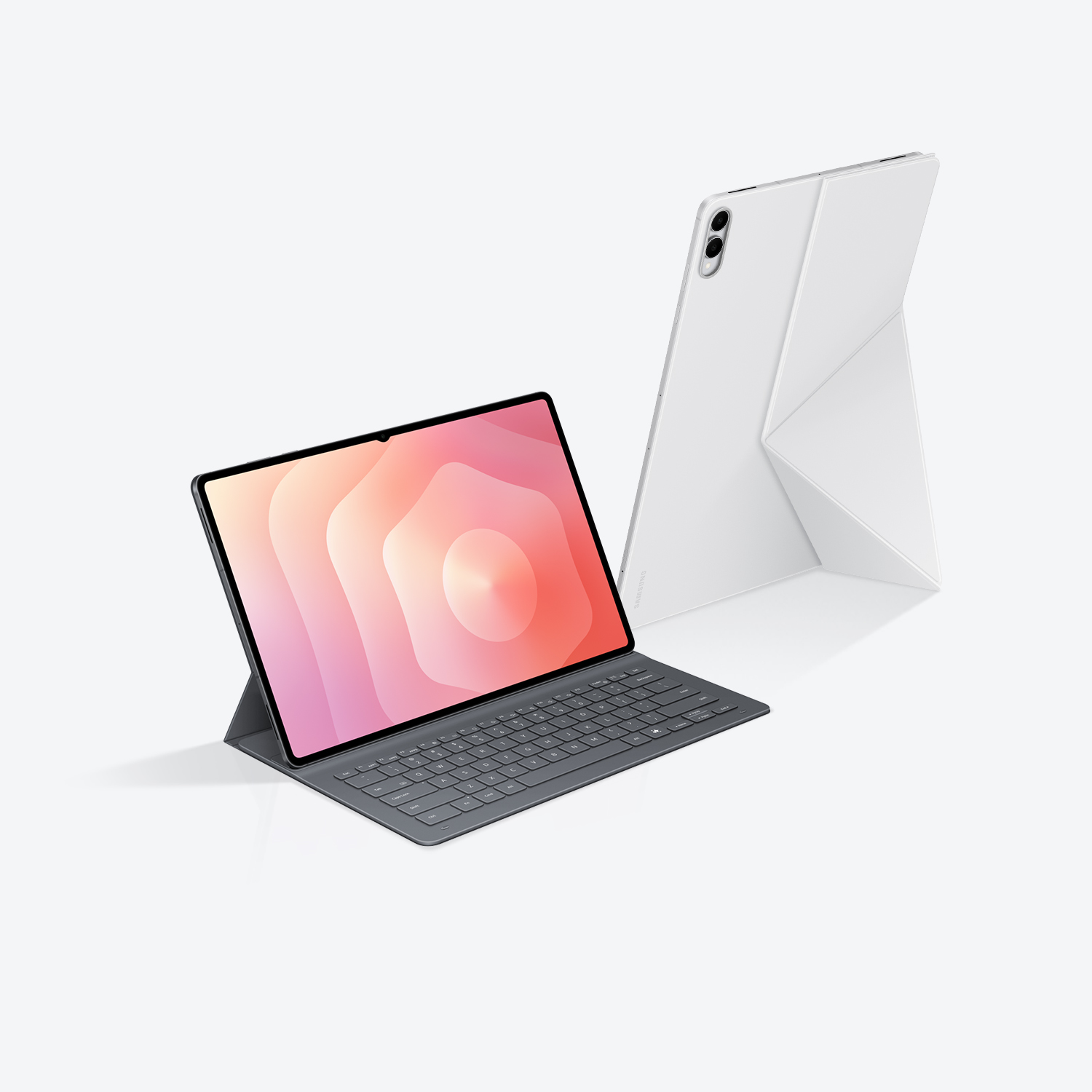 Dos tabletas con teclados. Una abierta, mostrando un diseño abstracto rosa y naranja, la otra, una cubierta de tableta blanca.