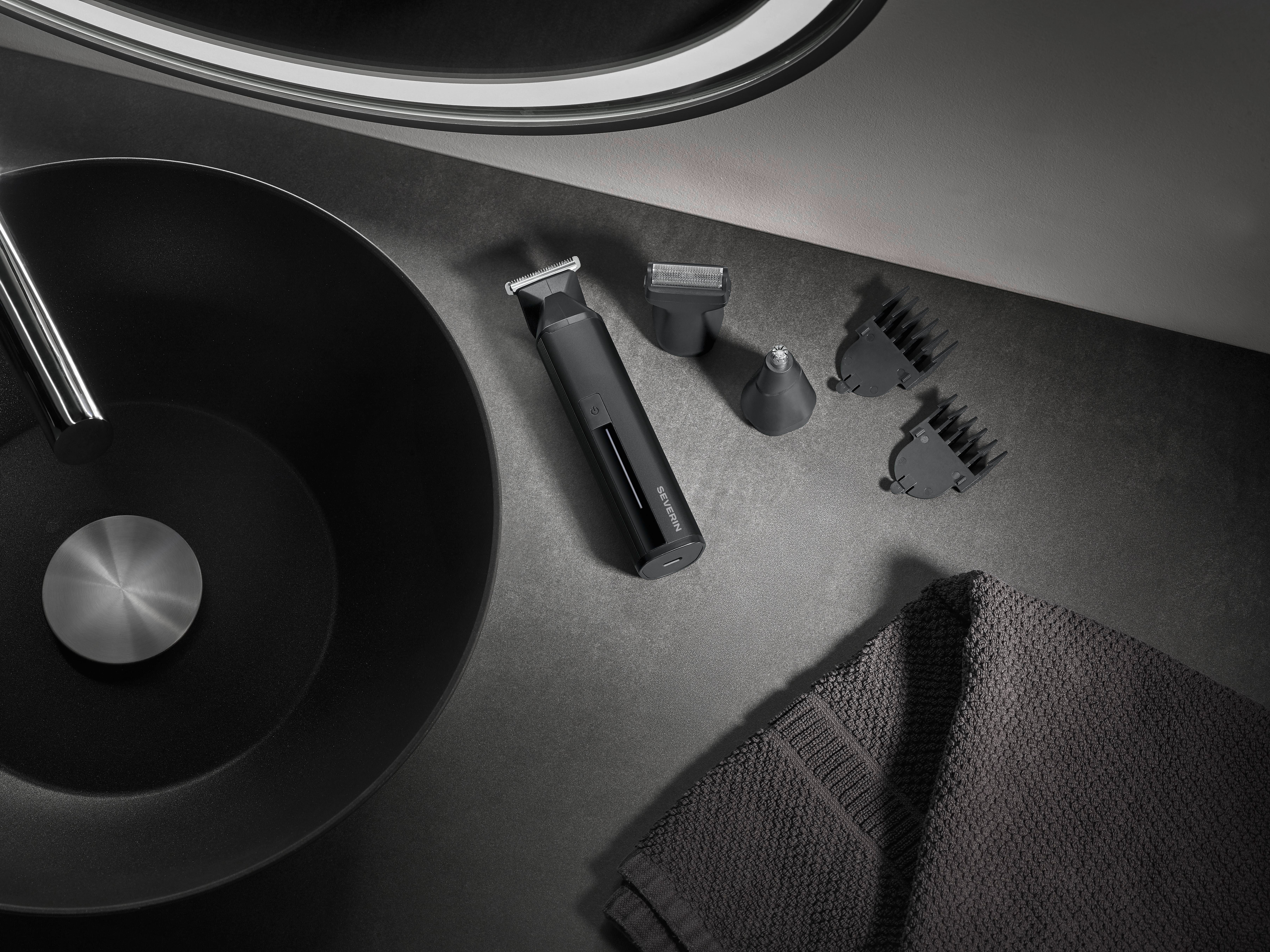 Czarny zestaw do pielęgnacji z nasadkami, ręcznikiem i umywalką na szarej powierzchni.