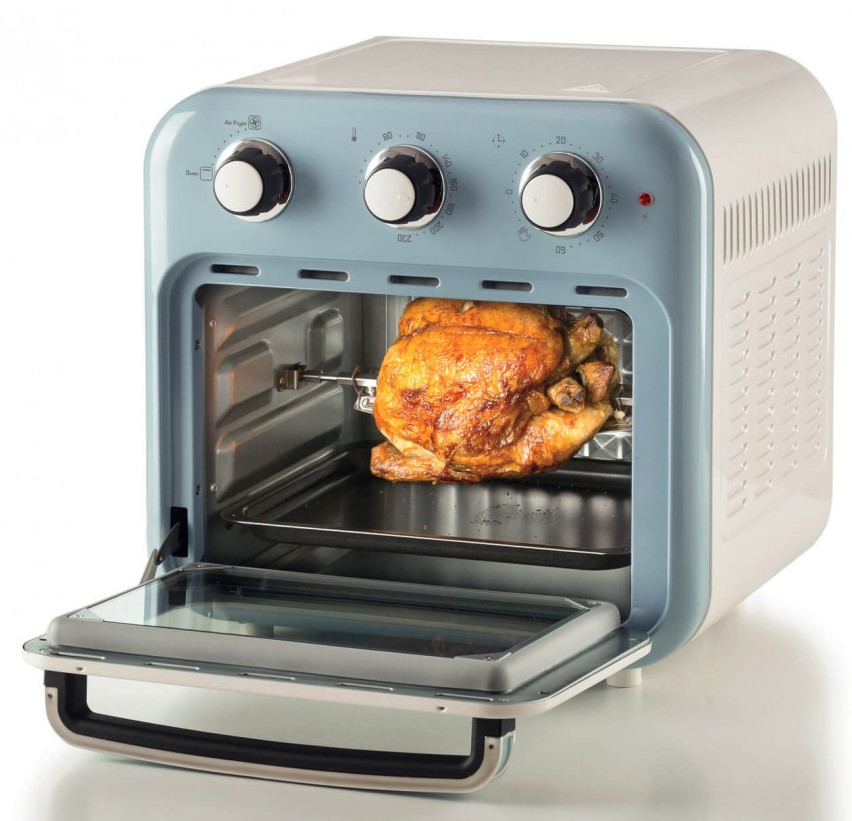 Frytkownica powietrzna w stylu retro z upieczonym kurczakiem w środku. Drzwi piekarnika są otwarte. Urządzenie ma kolory biały i niebieski.