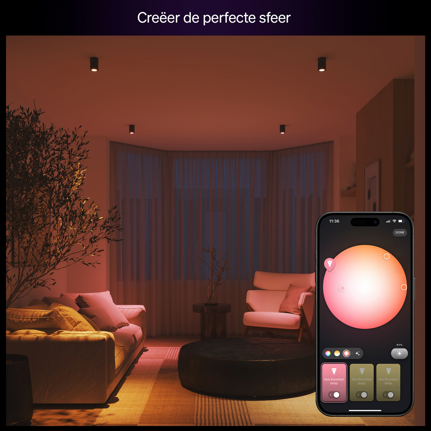 A living room with warm lighting, a couch, armchair, and a phone displaying a color adjustment interface. The text at the top says 'Creëer de perfecte sfeer'.