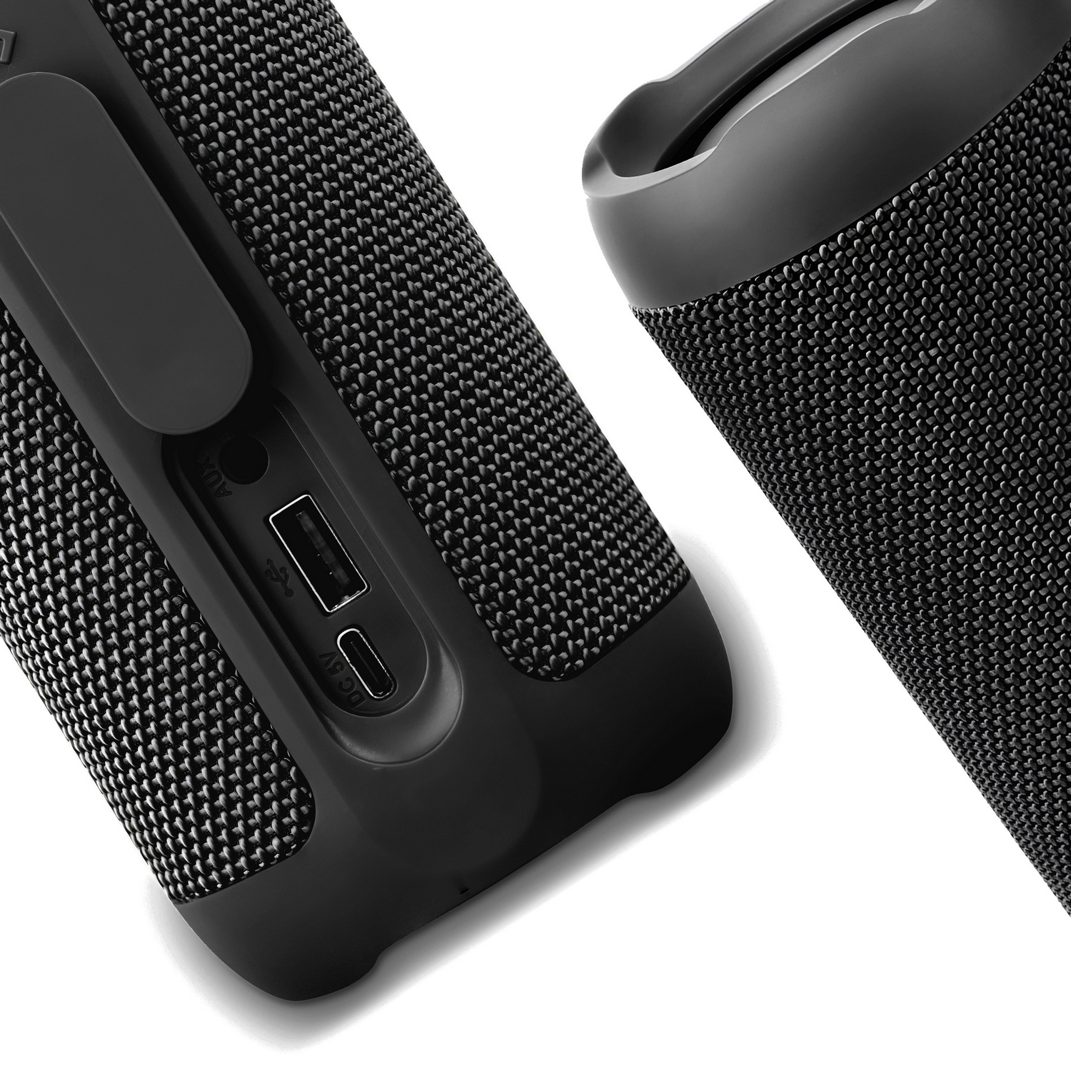 Dos altavoces portátiles negros. Uno con puertos visibles y otro con asa. Ambos tienen un diseño de tejido.