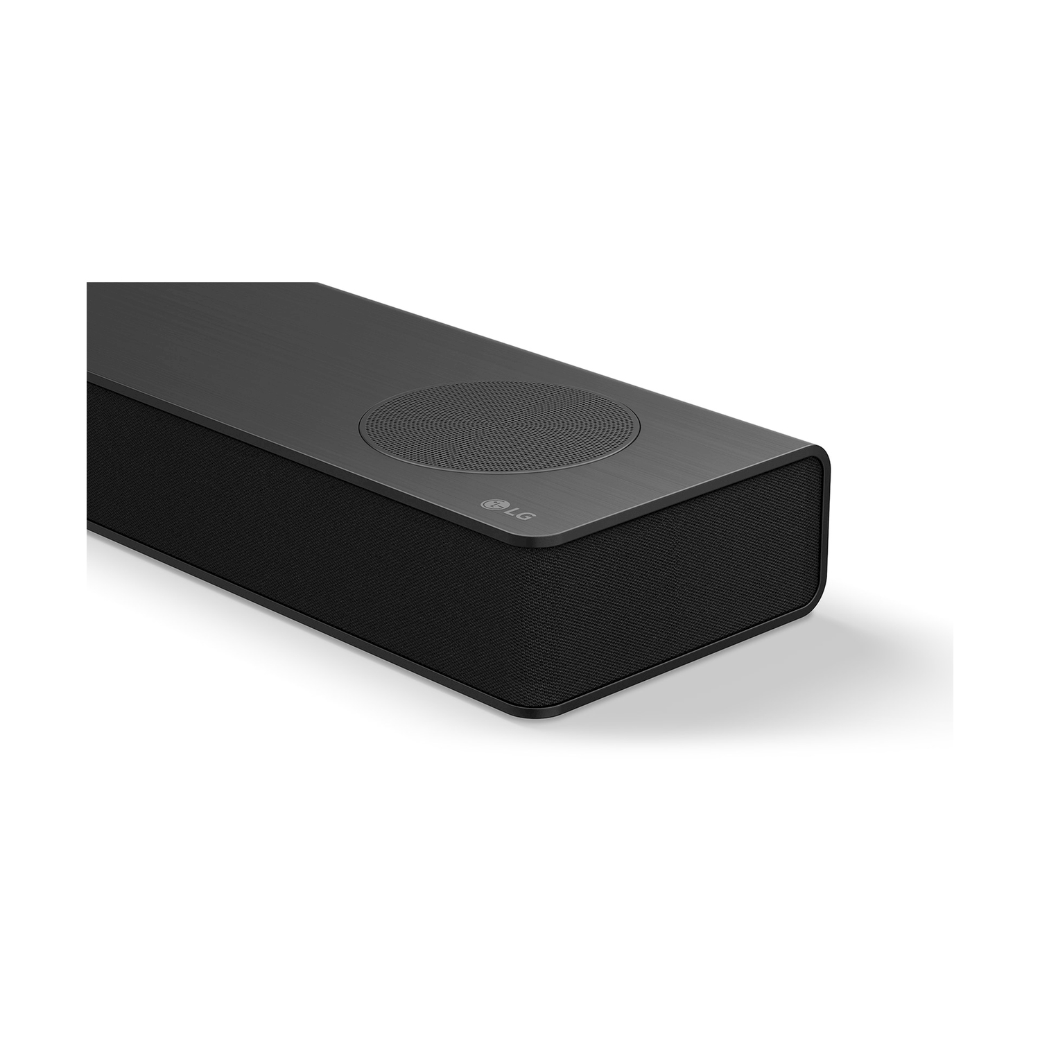 Primo piano di una soundbar LG nera su una superficie bianca. La soundbar ha un frontale in rete e una parte superiore metallica.