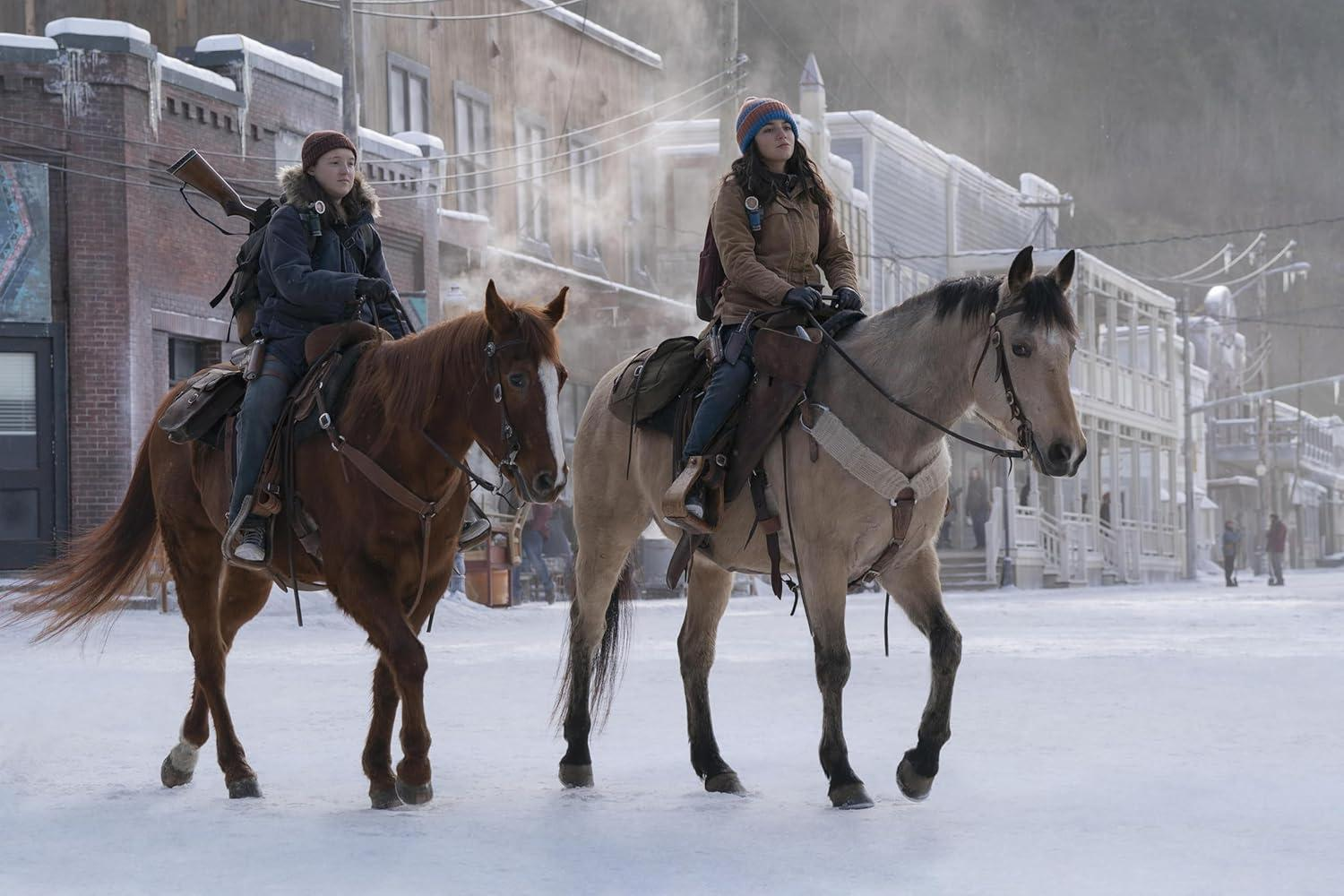 Zwei Frauen reiten auf Pferden durch eine verschneite Stadt. Ein Pferd ist braun, das andere grau. Gebäude säumen die Straße.