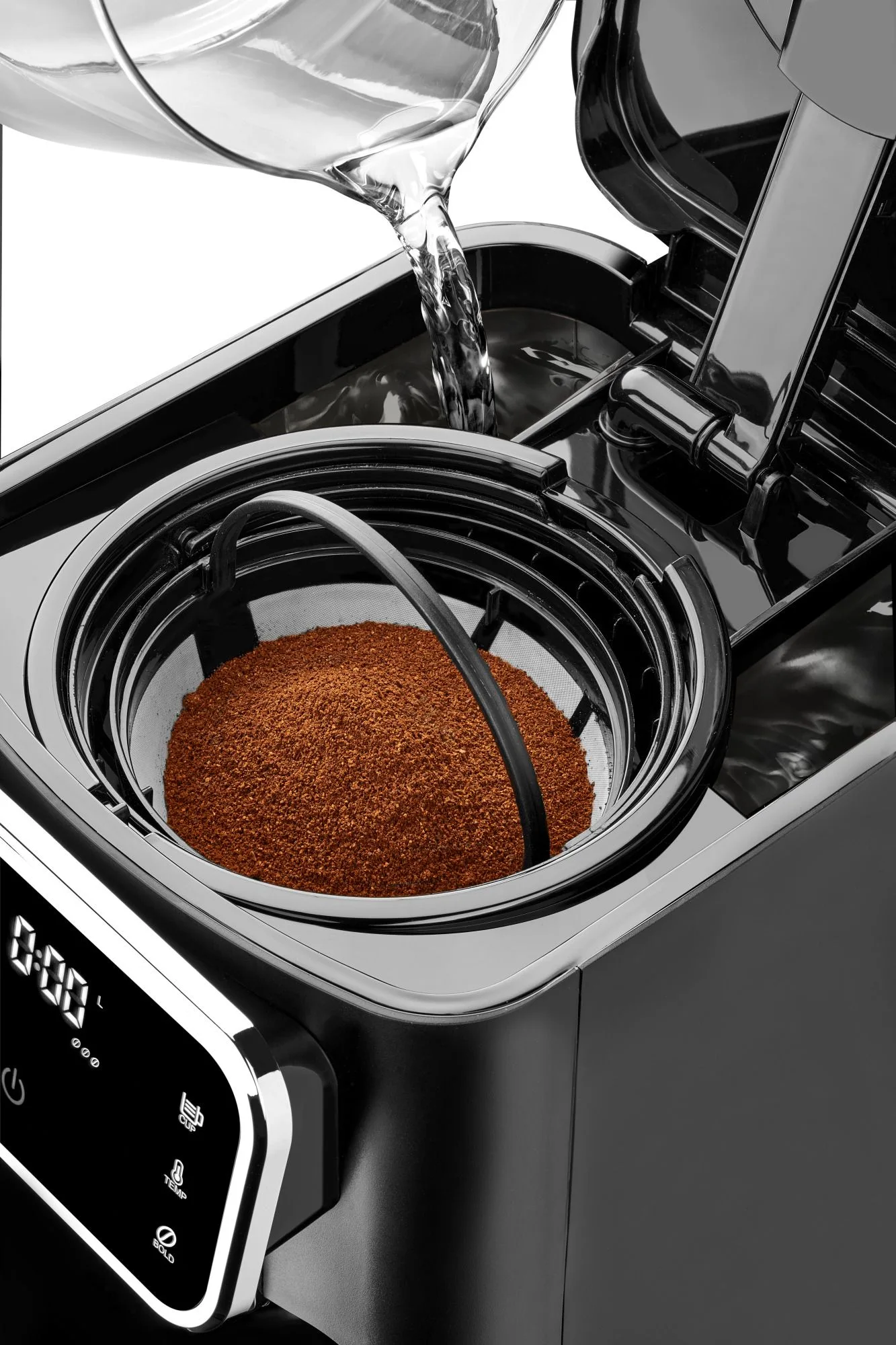 Woda wlewana do ekspresu do kawy z mieloną kawą. Wyświetlacz cyfrowy pokazuje czas. Maszyna jest czarna.