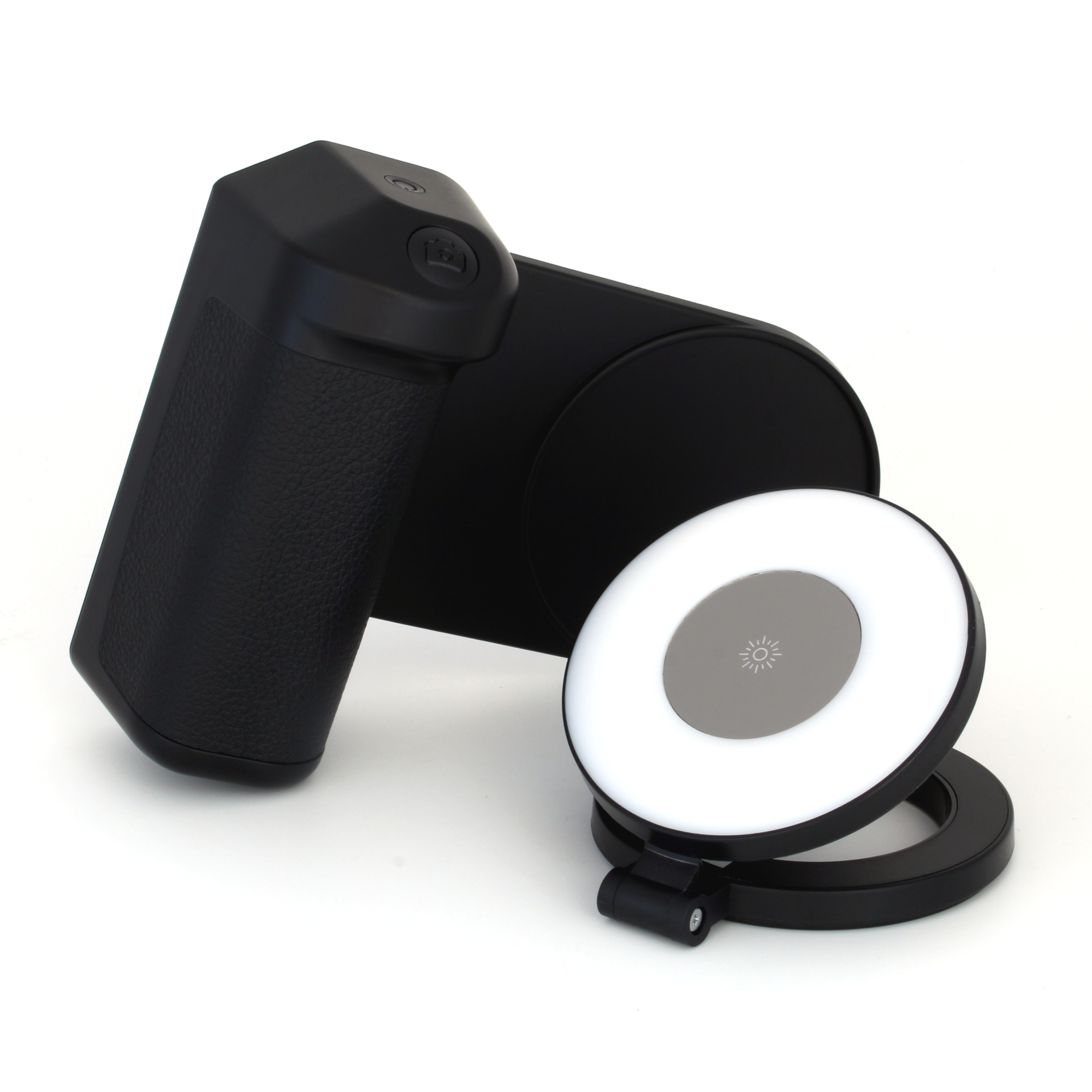 Ein schwarzer Kameragriff, eine flache schwarze Basis und ein Ringlicht mit silbernem Zentrum, alles auf weißem Hintergrund.