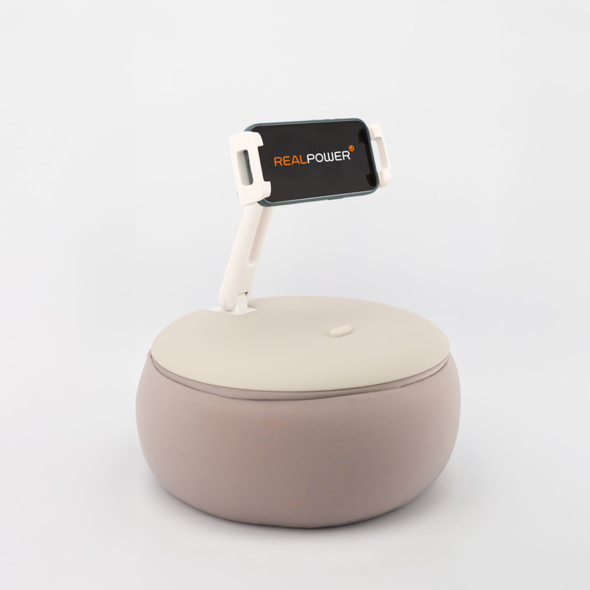 Ein auf einem Ständer befestigtes Telefon, das auf einer abgerundeten Basis aus Beige und Braun platziert ist. Auf dem Telefon wird das RealPower-Logo angezeigt.
