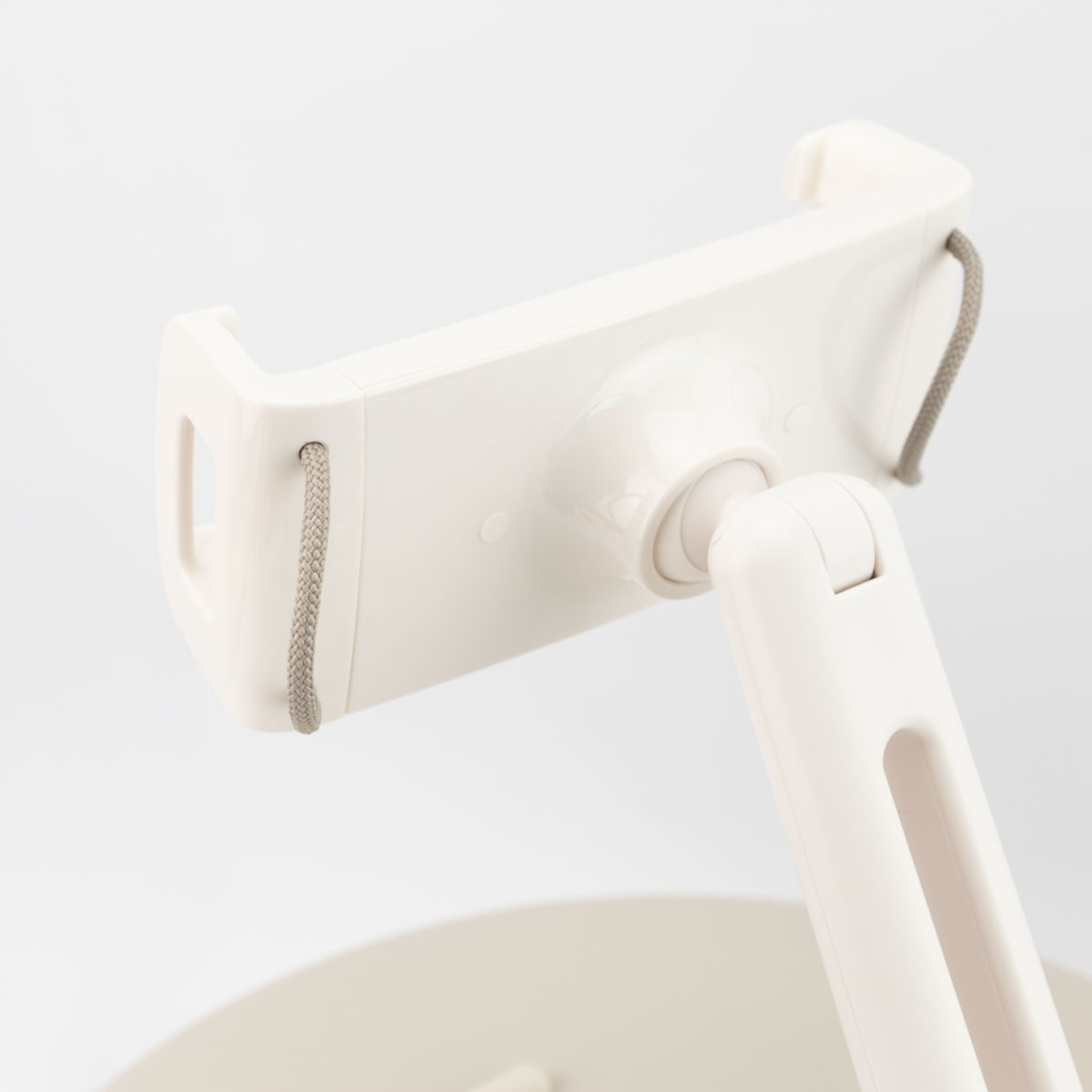 Weißer Telefonhalter auf weißem Hintergrund. Er hat einen flexiblen Arm und eine kreisförmige Basis. Der Halter ist abgewinkelt.