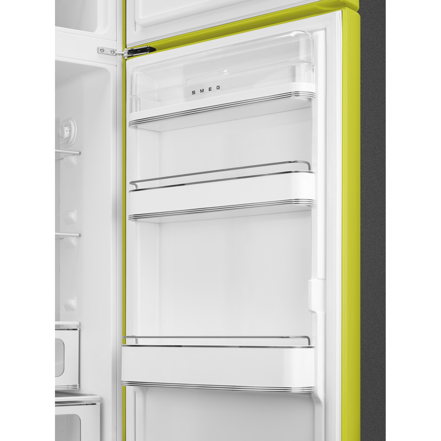 Interno del frigorifero Smeg verde lime aperto. Presenta ripiani trasparenti, finiture cromate e interni bianchi. La porta è aperta.
