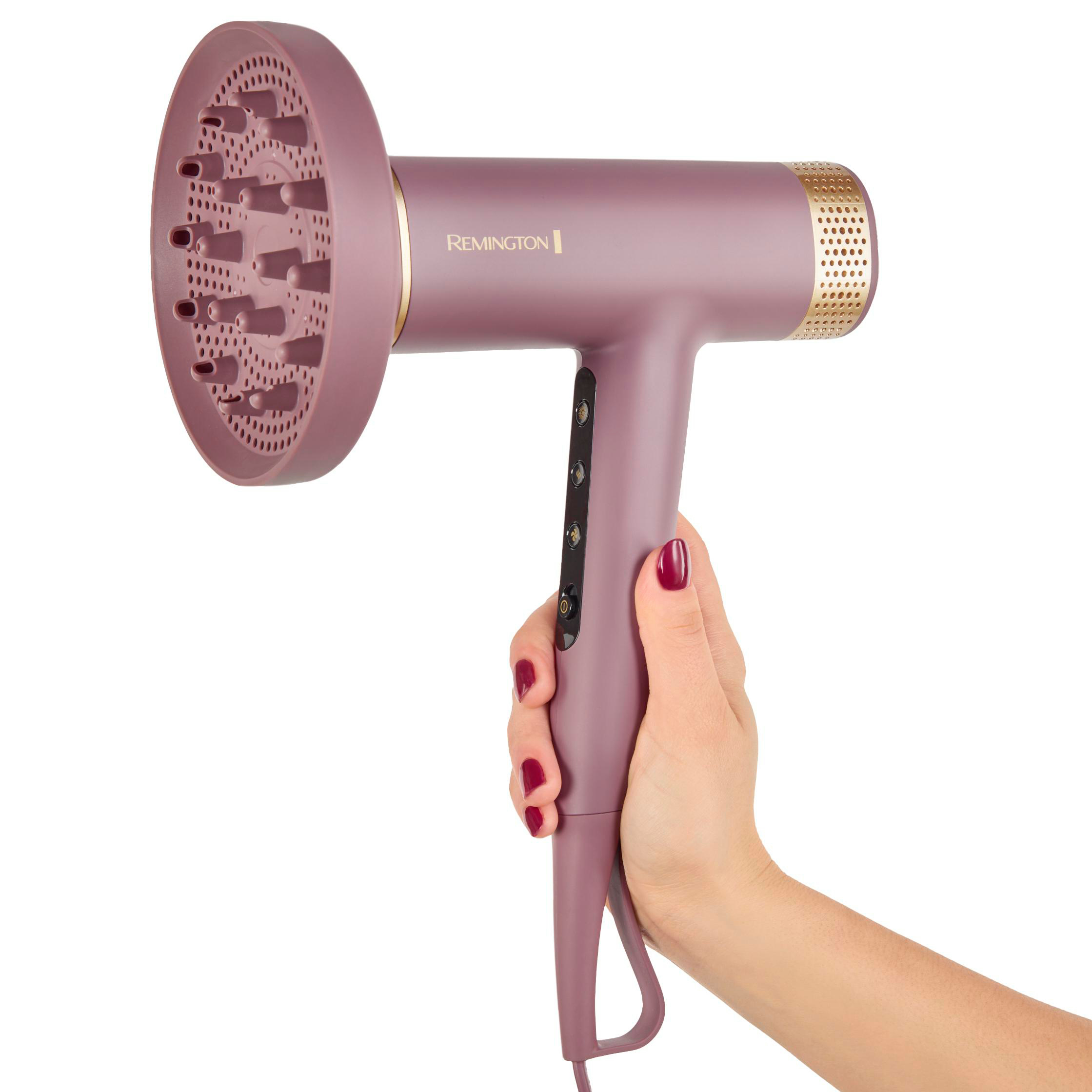 Eine Hand hält einen mauvefarbenen Remington-Haartrockner mit Diffusor. Die Hand hat roten Nagellack. Weißer Hintergrund.