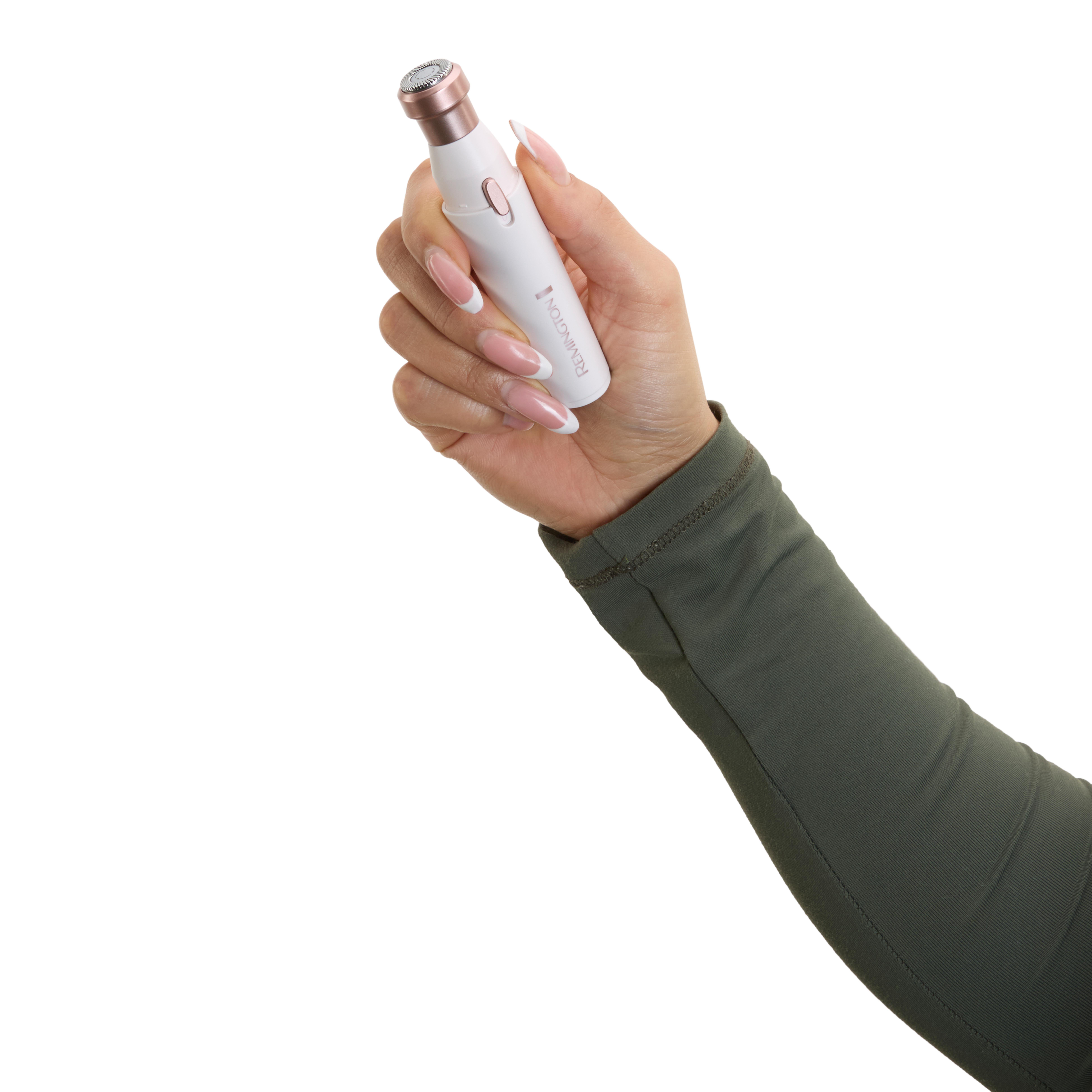 Eine Hand hält einen weißen und roségoldenen Remington Epilierer. Der Arm ist mit einem grünen Ärmel bedeckt. Der Hintergrund ist weiß.