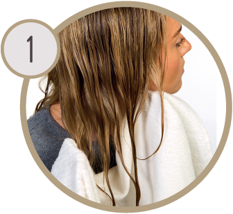 Frau trocknet nasse Haare mit einem weißen Handtuch. Nummer 1 in einem Kreis vorhanden.