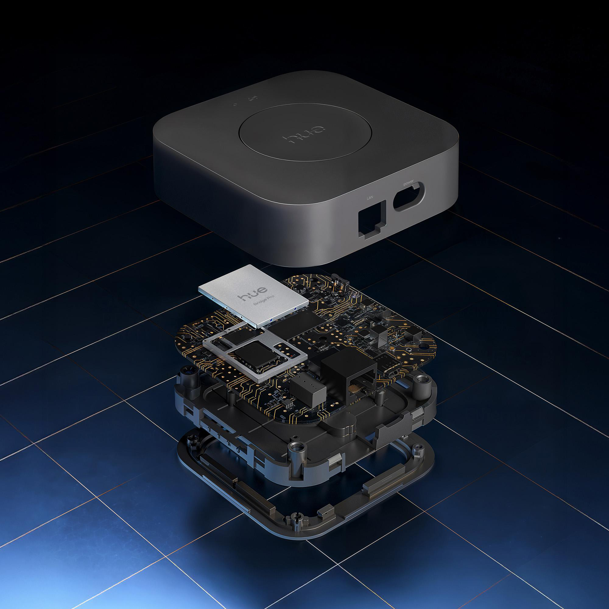 Explosionsansicht einer schwarzen Hue Bridge mit sichtbaren Innenkomponenten, vor dunklem blauem Gitterhintergrund.