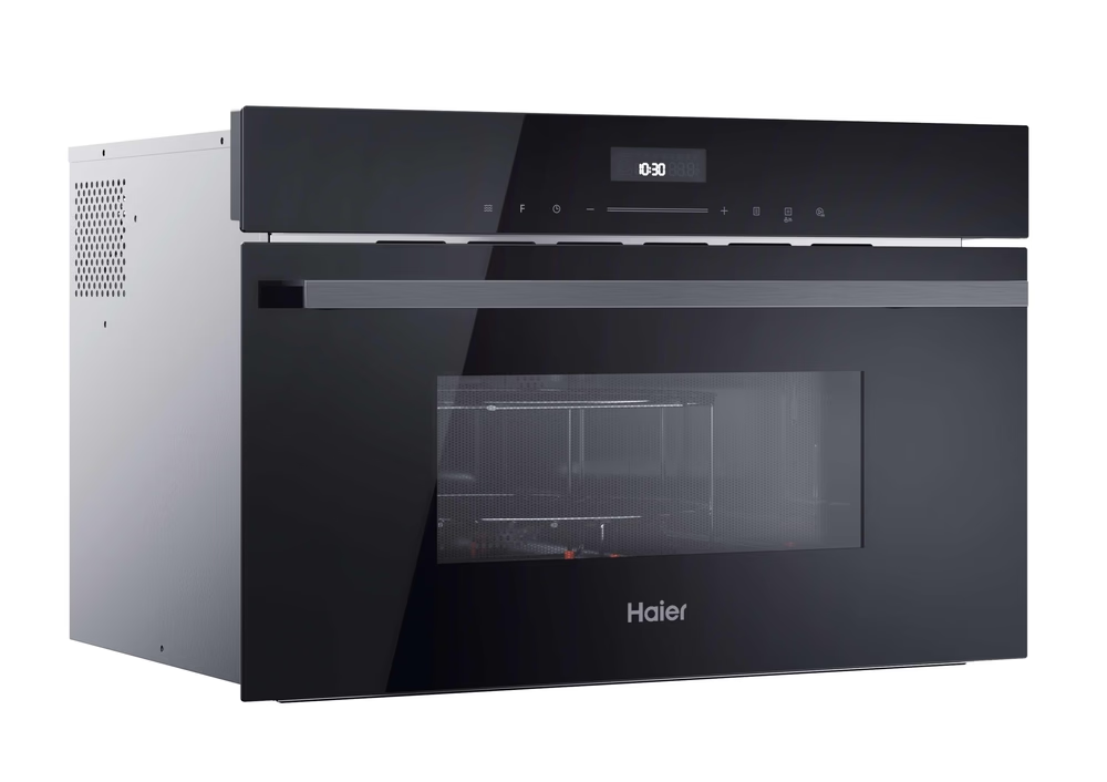 Egy fekete Haier mikrohullámú sütő. Digitális óra kijelzője és üvegajtaja van. A sütő fehér háttér előtt van.