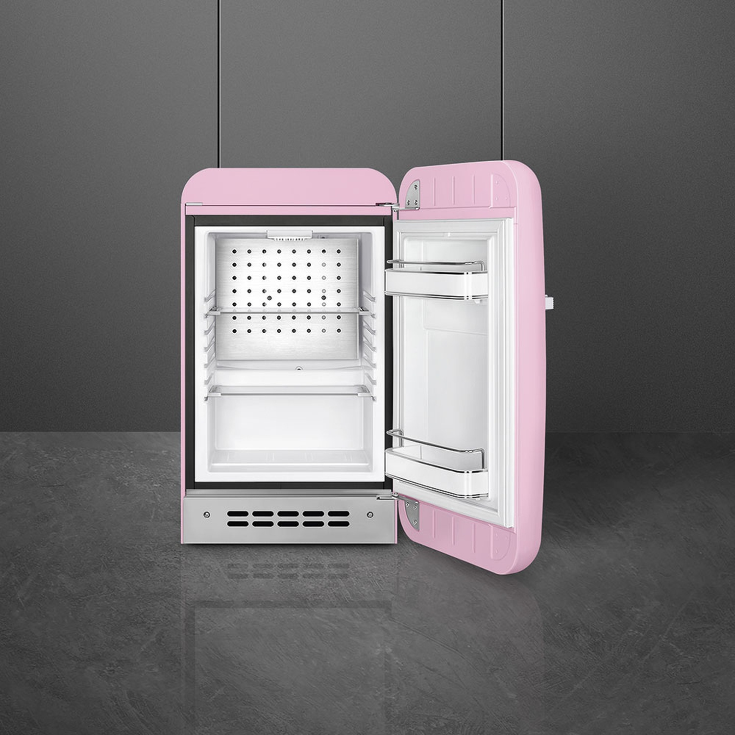 Un mini-frigorifero retrò rosa con la porta aperta. Ha dettagli cromati ed è su uno sfondo grigio scuro.