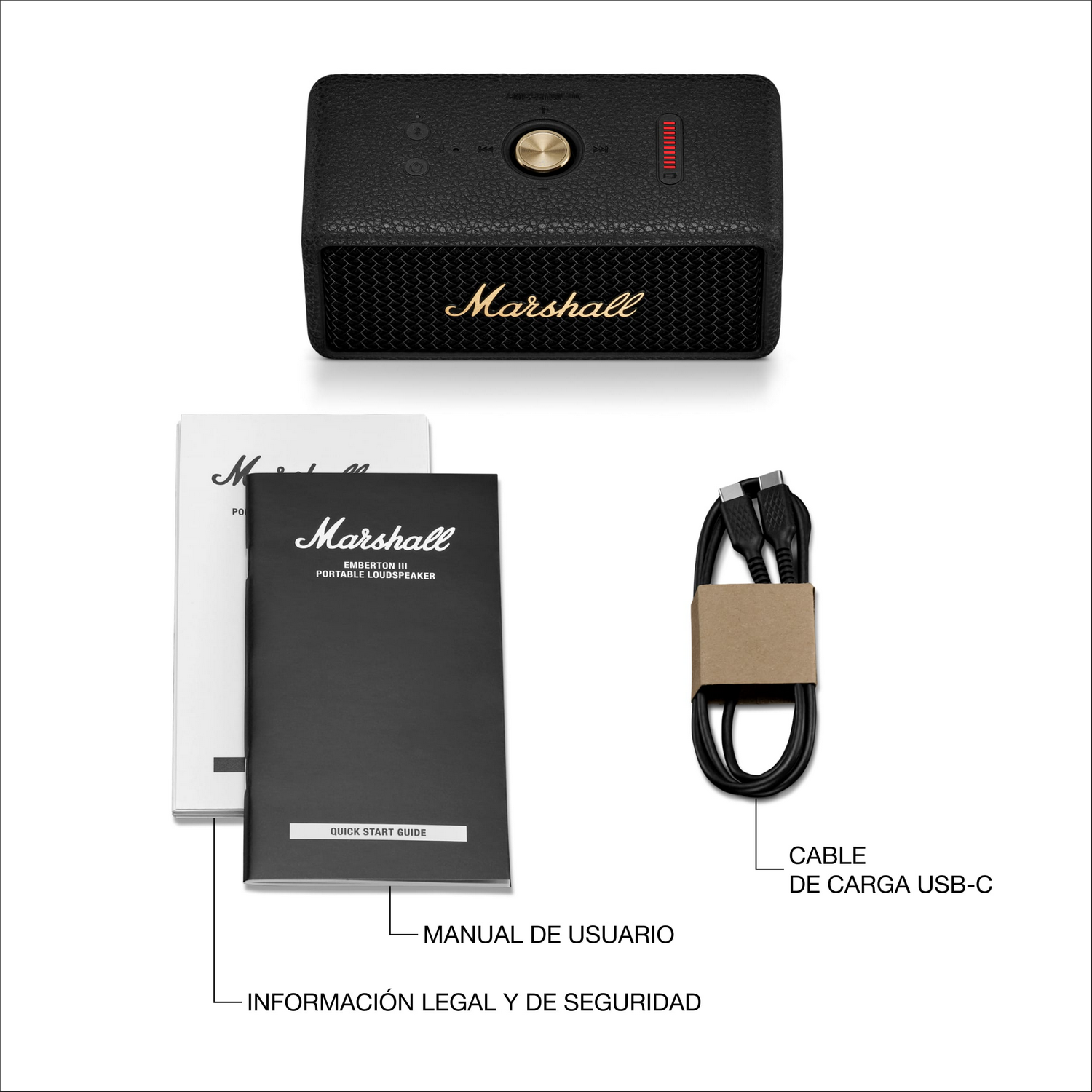 Altavoz negro Marshall Emberton III, manual del usuario y cable de carga USB-C sobre superficie blanca. El altavoz tiene controles y un logotipo dorado.