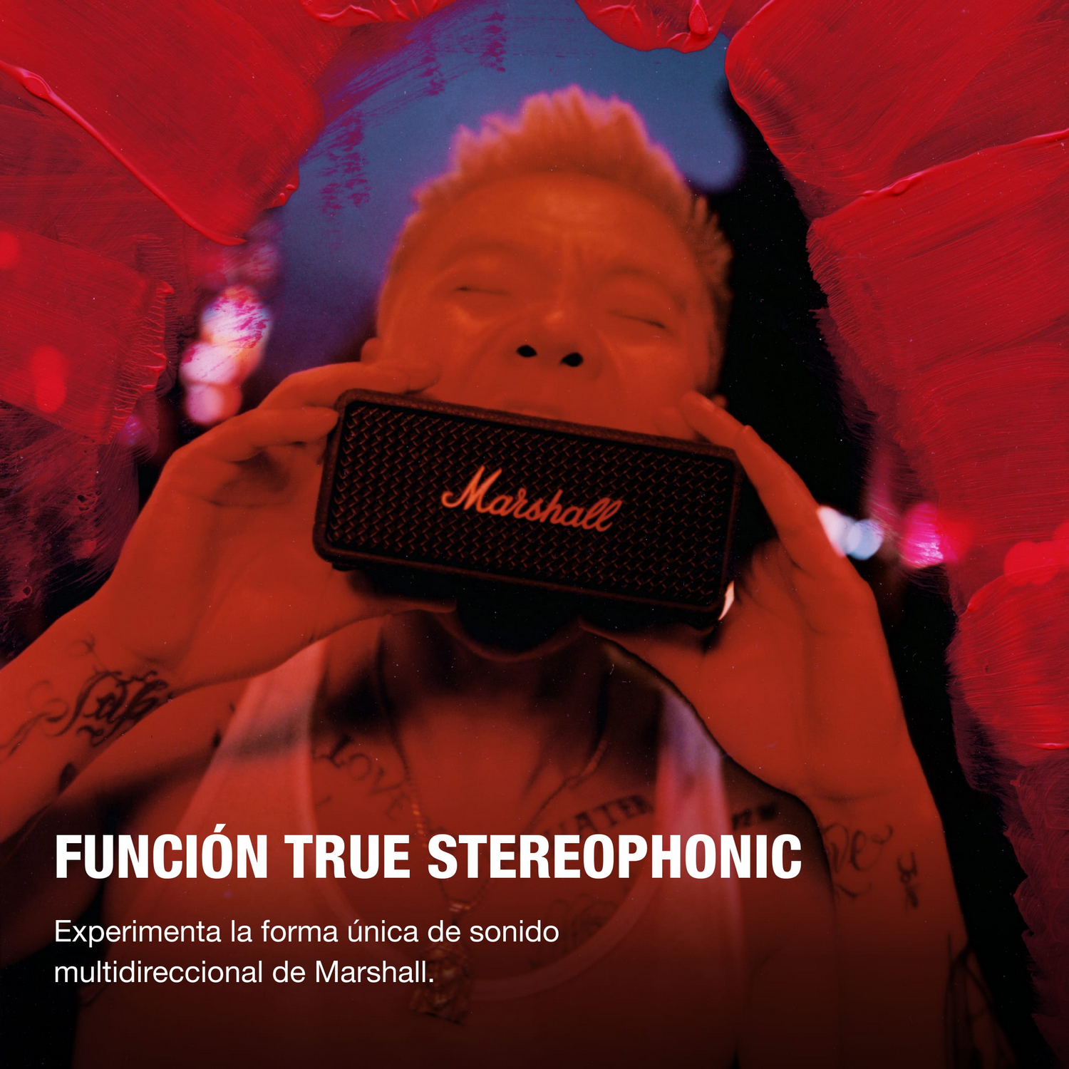 Una persona sostiene un altavoz Marshall cerca de su boca. Trazos de pintura roja rodean a la persona. El texto dice "FUNCIÓN TRUE STEREOPHONIC".