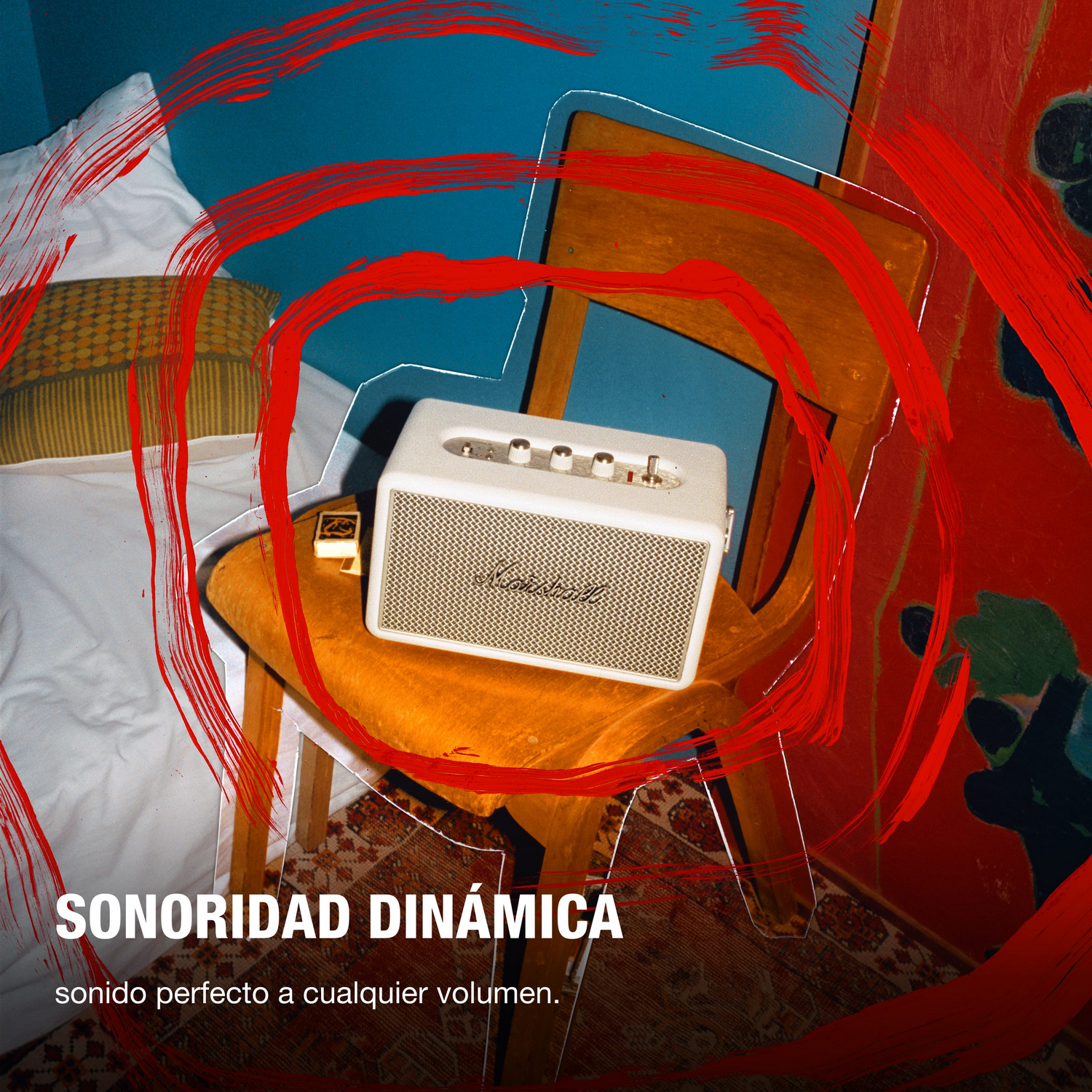 Un altavoz blanco está sobre una silla de madera contra una pared azul. Pinceladas rojas enmarcan la escena con texto: SONORIDAD DINÁMICA.