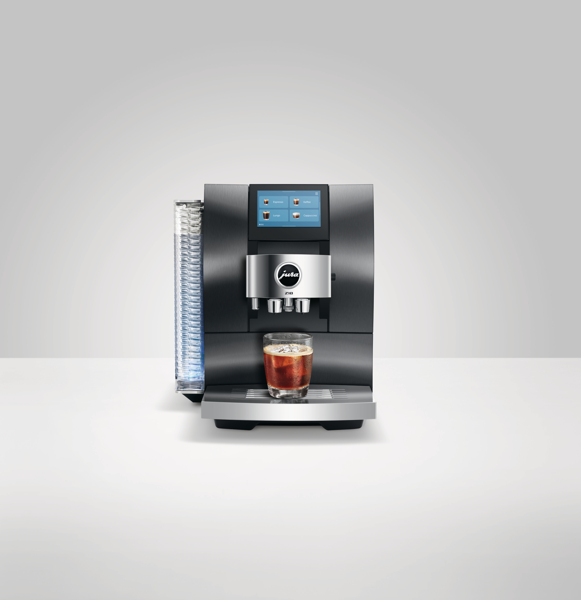 Eine moderne schwarze Kaffeemaschine mit Touchscreen. Ein Glas Eiskaffee steht darunter. Weißer Hintergrund.