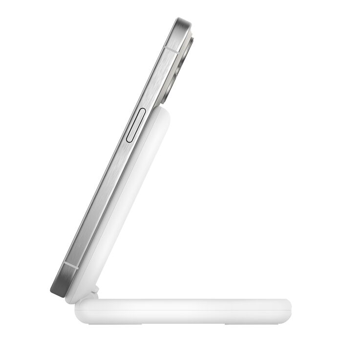 Un smartphone plateado descansa sobre un cargador inalámbrico blanco. El cargador está inclinado, con una base que sostiene el teléfono.