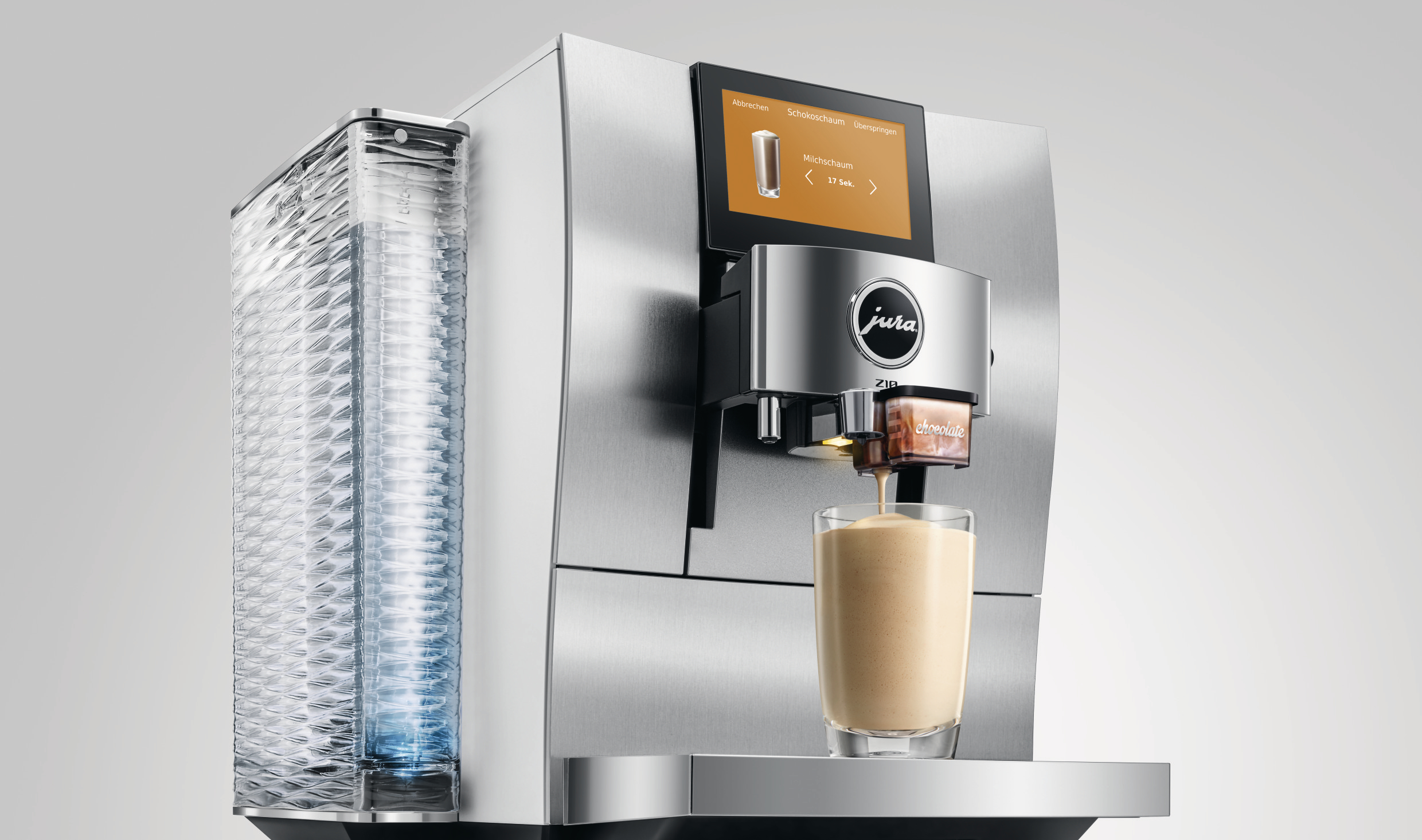 Eine Jura-Kaffeemaschine, die ein Getränk in ein Glas ausgibt. Mit digitalem Bildschirm und klarem Wasserbehälter.