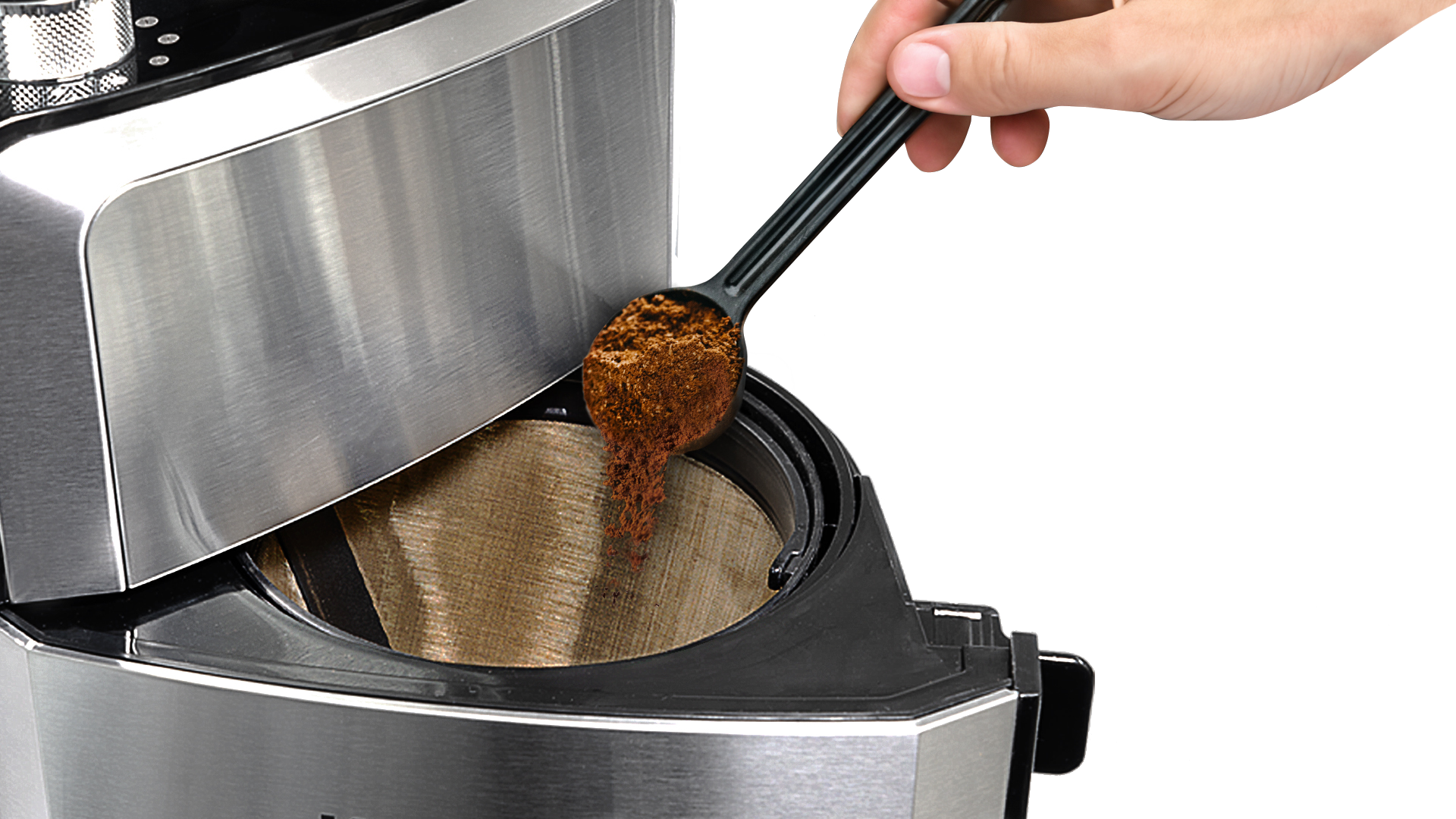 Ręka wlewa zmieloną kawę z czarnej łyżki do filtra ekspresu do kawy. Ekspres do kawy jest srebrny.
