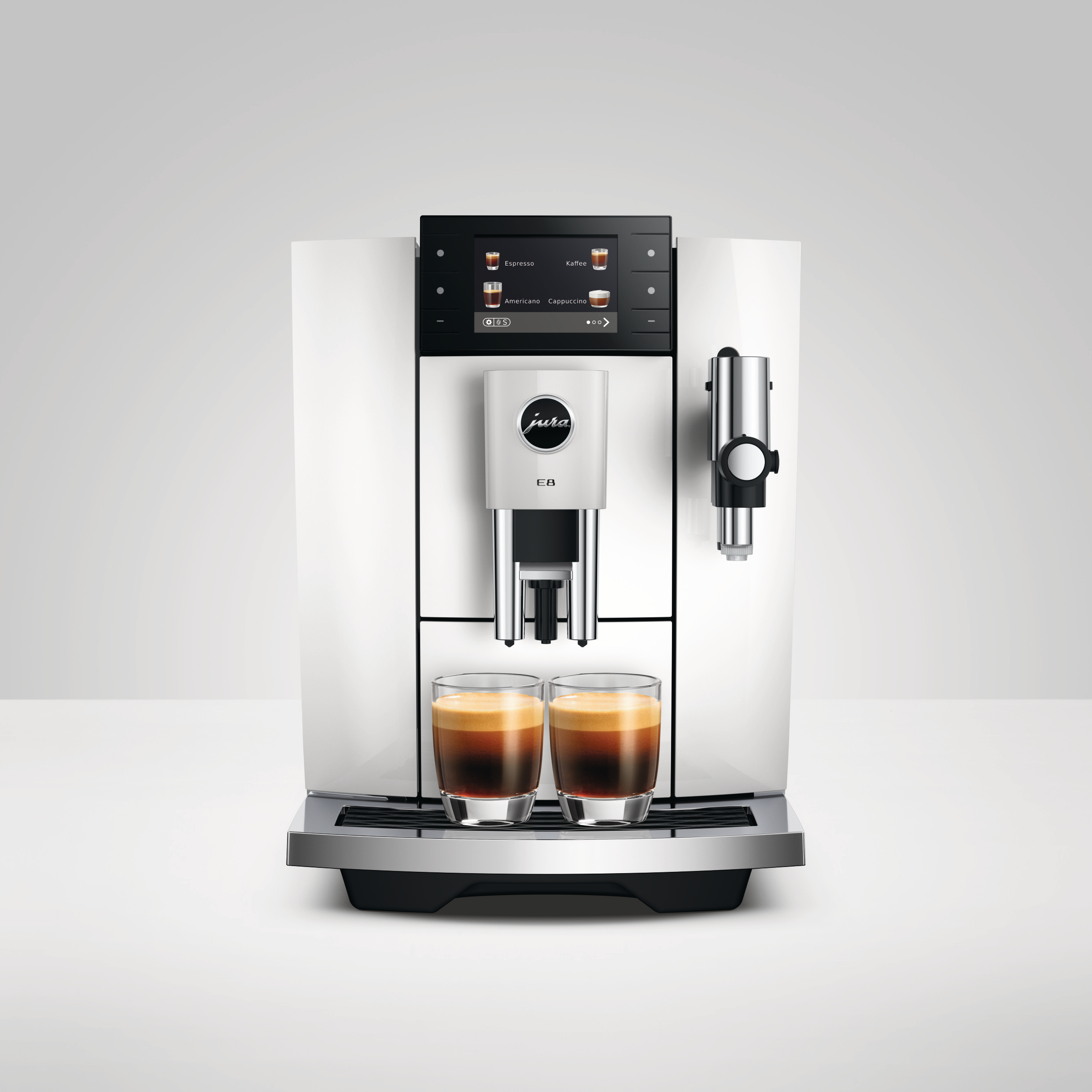 Eine weiße Jura E8 Kaffeemaschine mit zwei Espressi in Gläsern. Schwarzer Bildschirm zeigt Kaffeeoptionen.