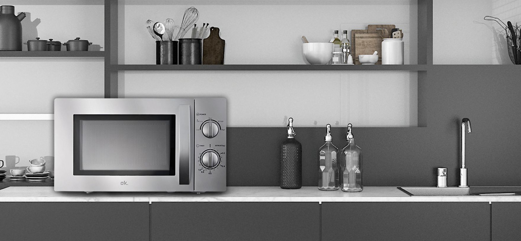 Srebrna kuchenka mikrofalowa stoi na blacie. Półki nad nim zawierają przybory kuchenne i butelki. Po prawej stronie znajduje się kran.