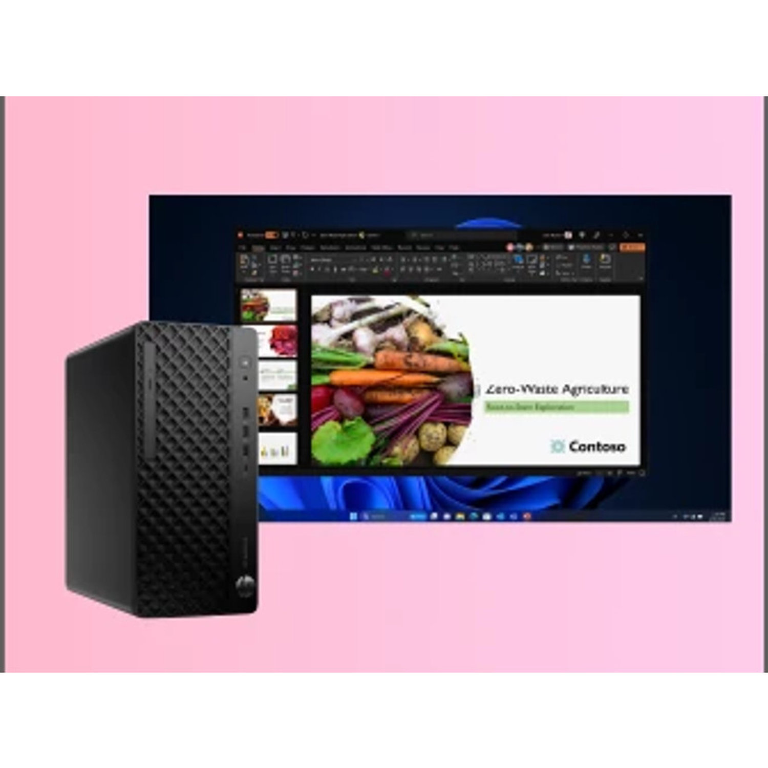 A black desktop computer next to a monitor displaying a presentation about zero-waste agriculture with vegetables.