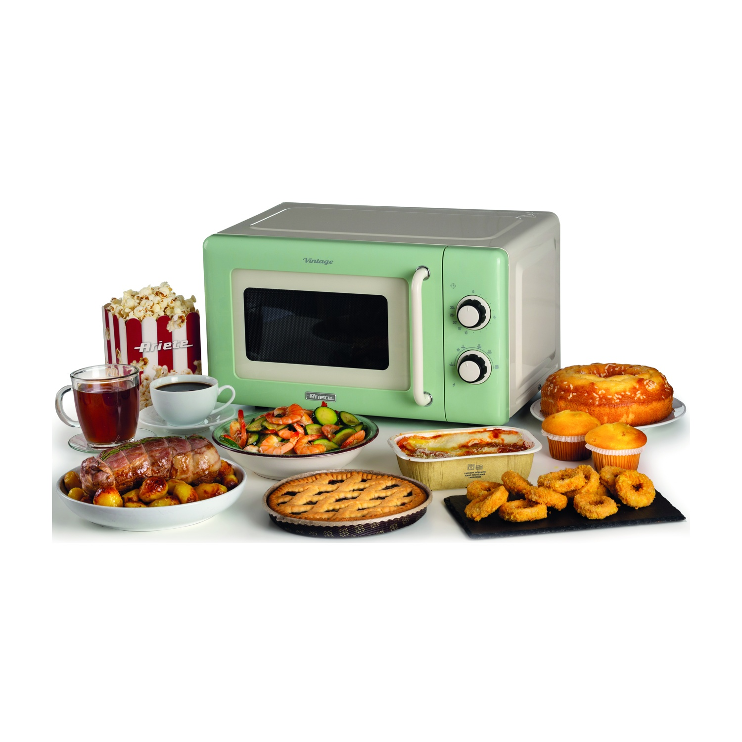 Un forno a microonde verde con cibi come popcorn, caffè, carne, torta, anelli di cipolla e torta disposti su una superficie bianca.