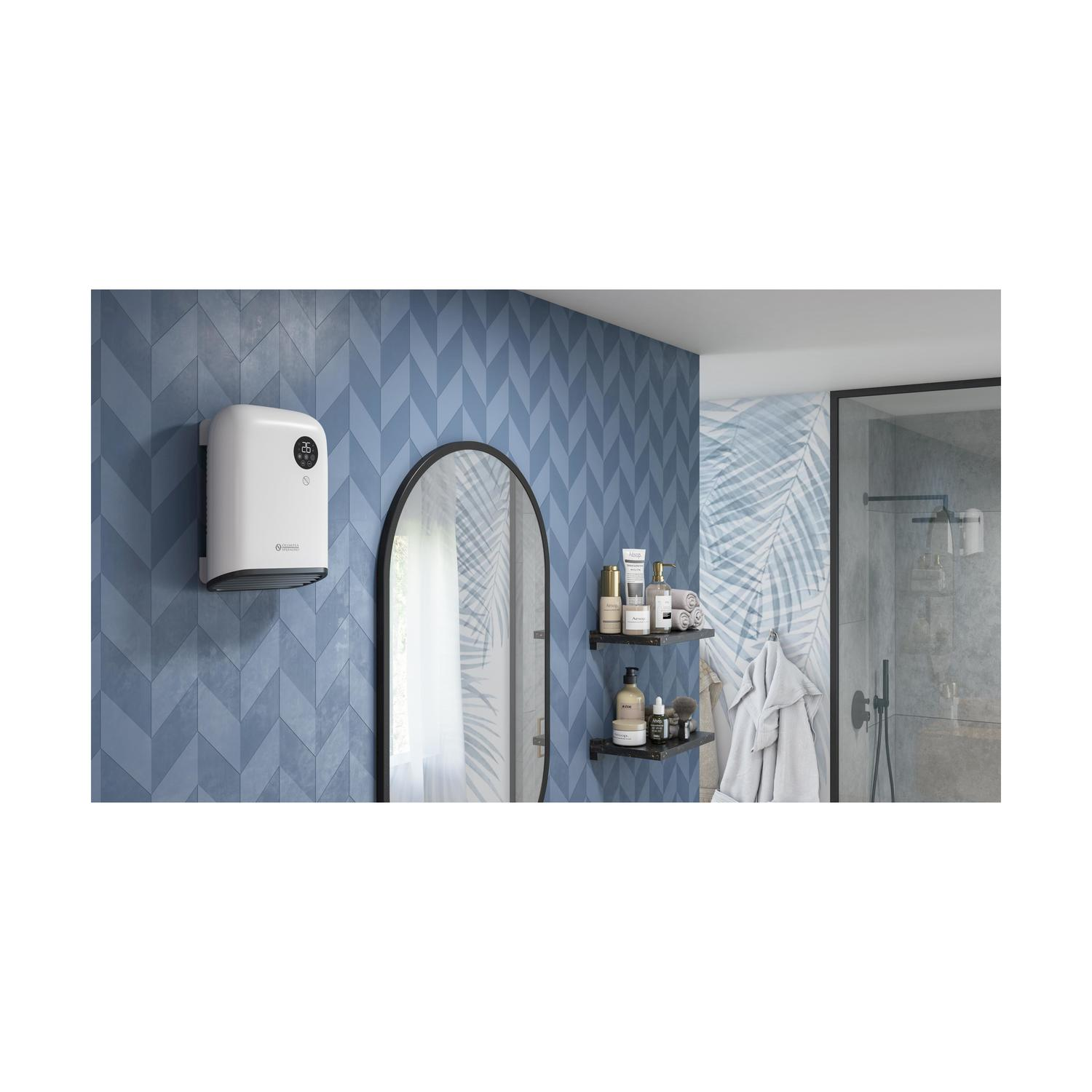 Scena bagno con scaldabagno bianco su parete blu, specchio con cornice nera e mensole con articoli da toeletta.