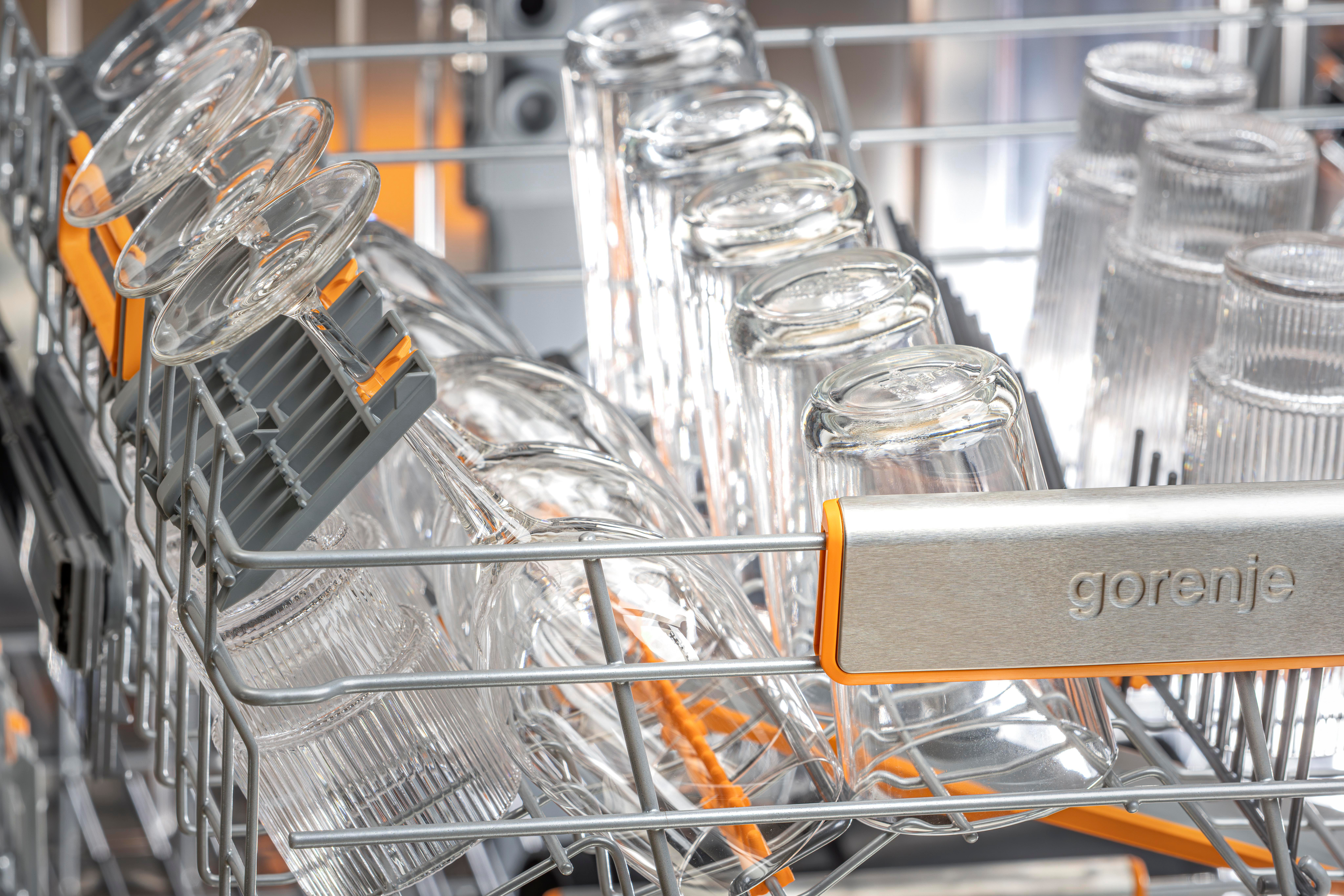 In einem Geschirrspüler werden klare Gläser kopfüber in einem Metallgestell platziert. Die Marke 'gorenje' ist sichtbar.