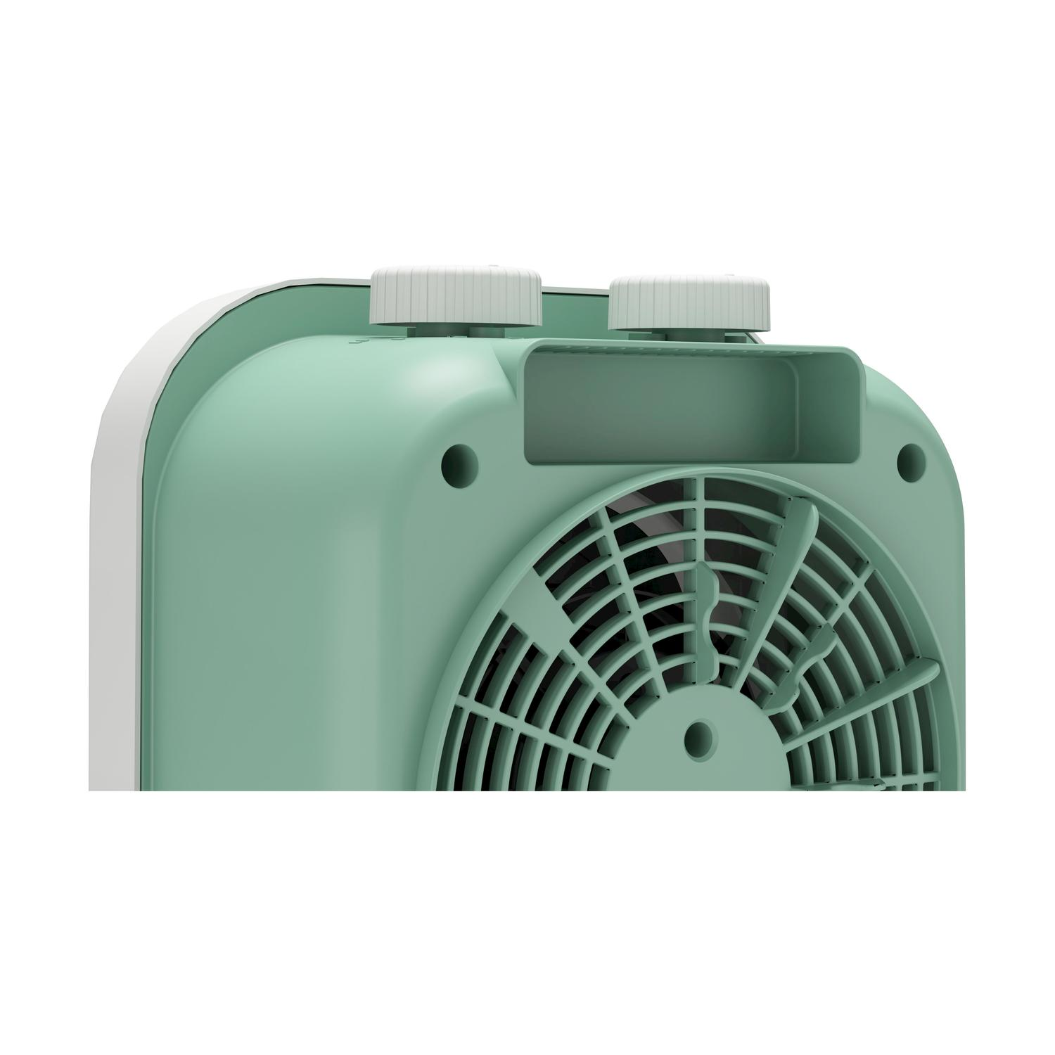 Primo piano di un ventilatore verde e bianco. Due manopole bianche sono in cima e una griglia del ventilatore è visibile. Lo sfondo è bianco.