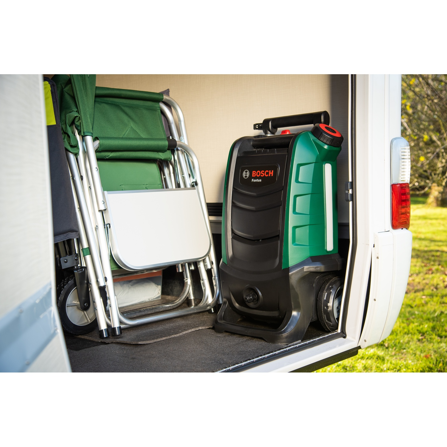 Un'idropulitrice Bosch Fontus verde e nera è all'interno di un furgone bianco. Accanto c'è una sedia verde piegata. La porta è aperta.